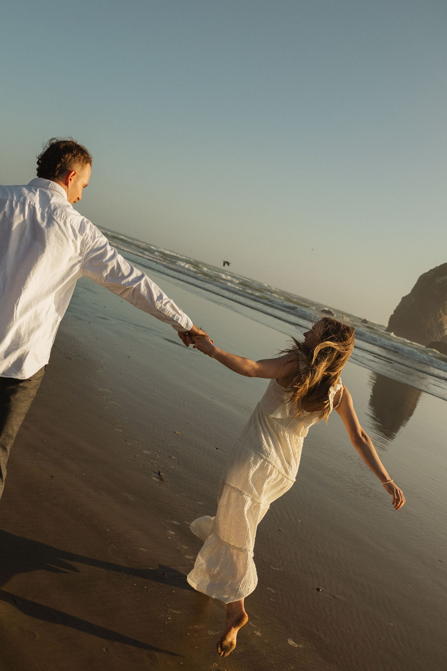 couple running on cannon beach in oregon