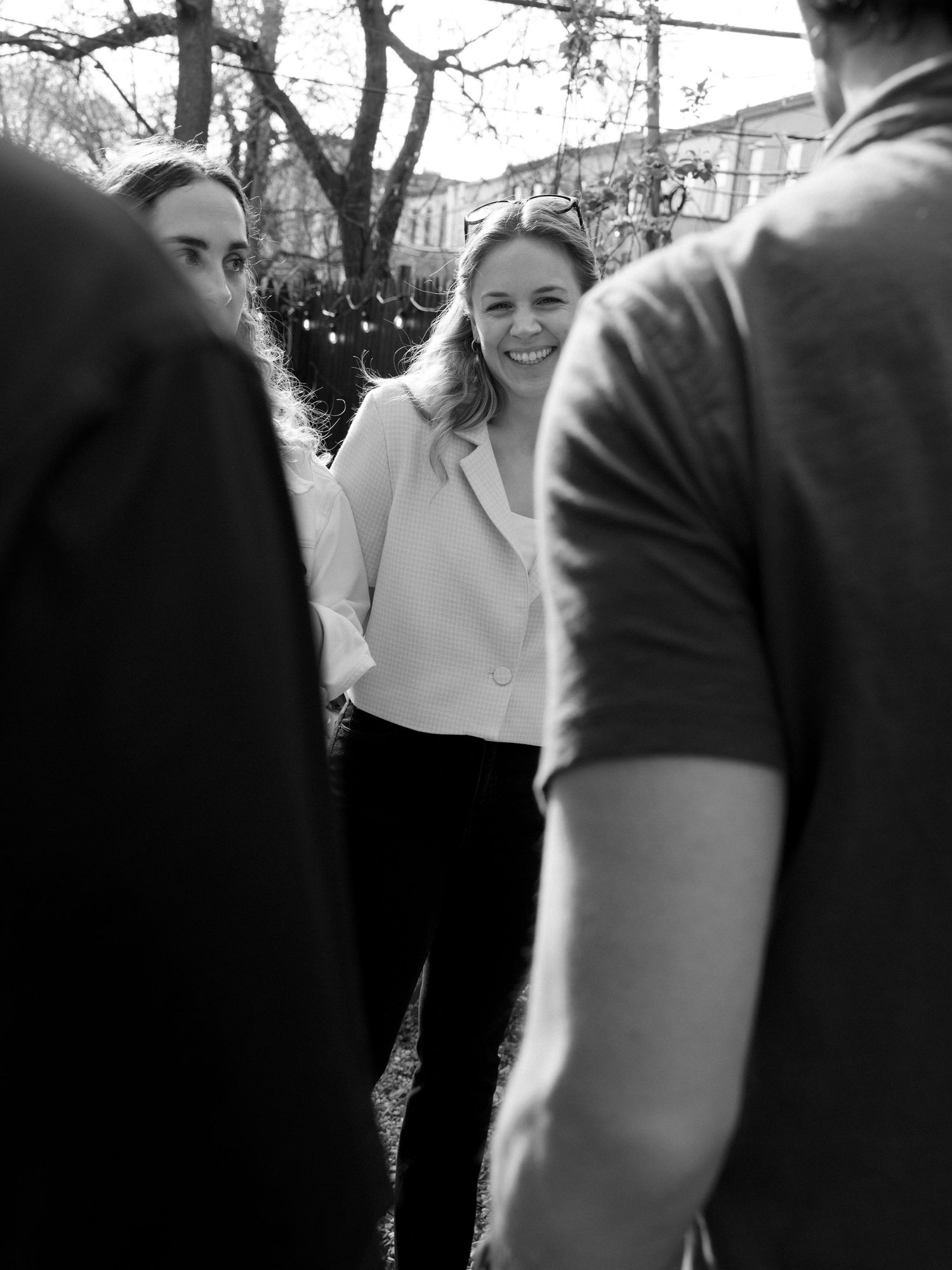 Outdoor social gathering with people mingling in black and white photography.