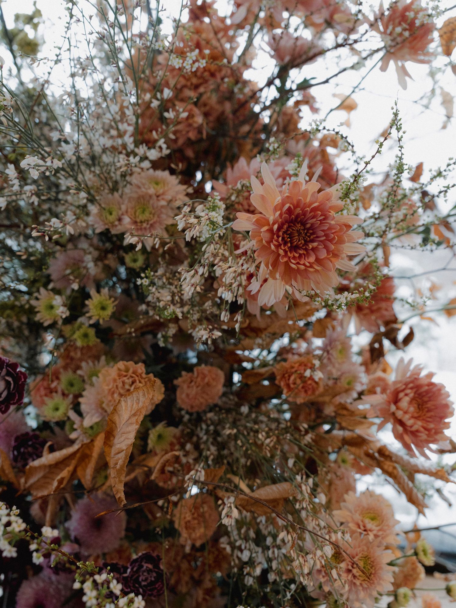 Close-up of a romantic autumn floral arrangement with pink and peach blooms.