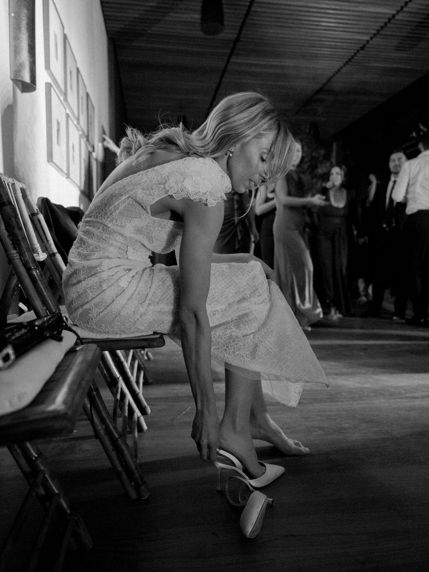Black and white image showing wedding dress details and dancing shoes on a dance floor.