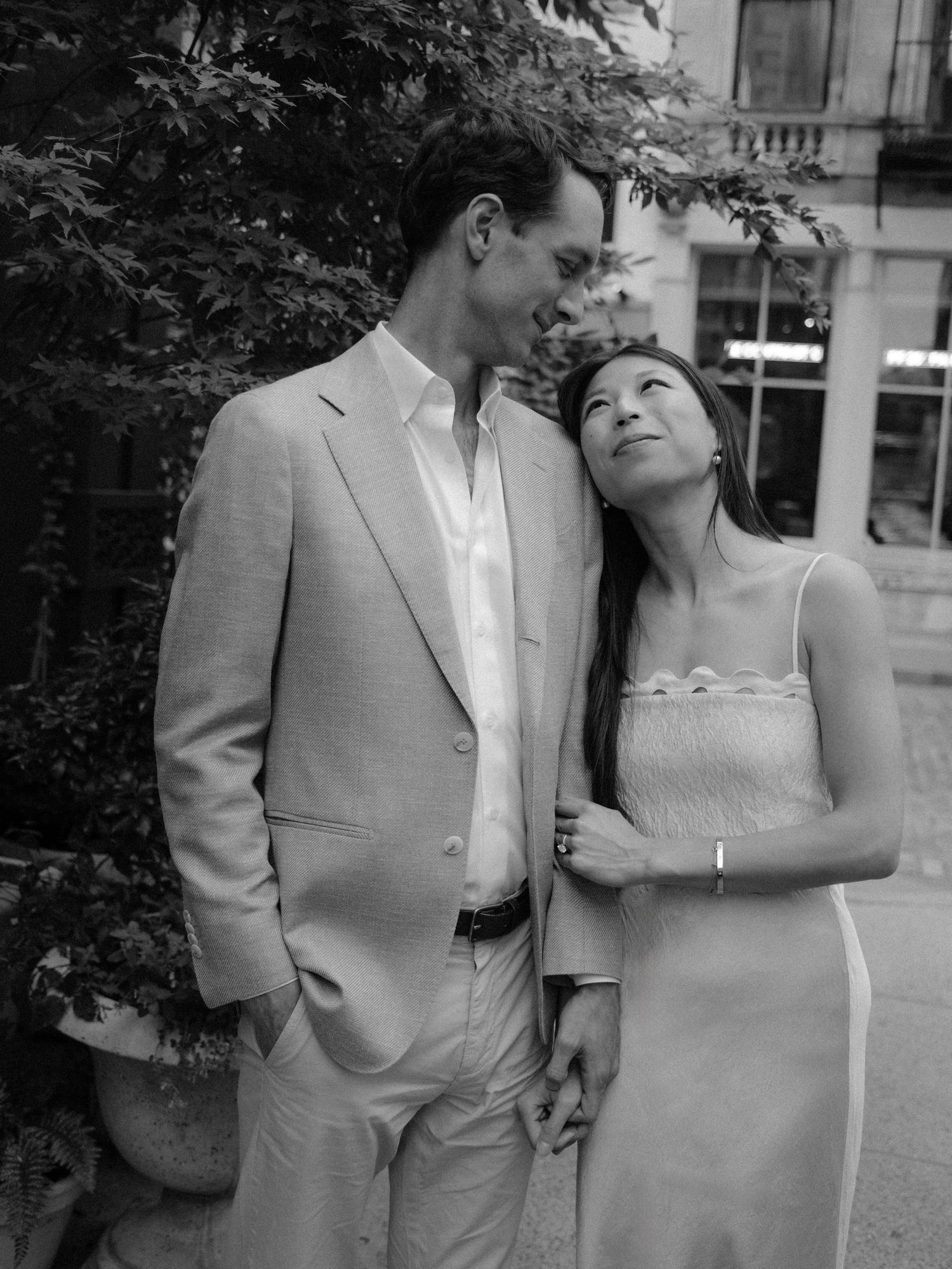 Elegant couple sharing intimate moment in outdoor urban setting.