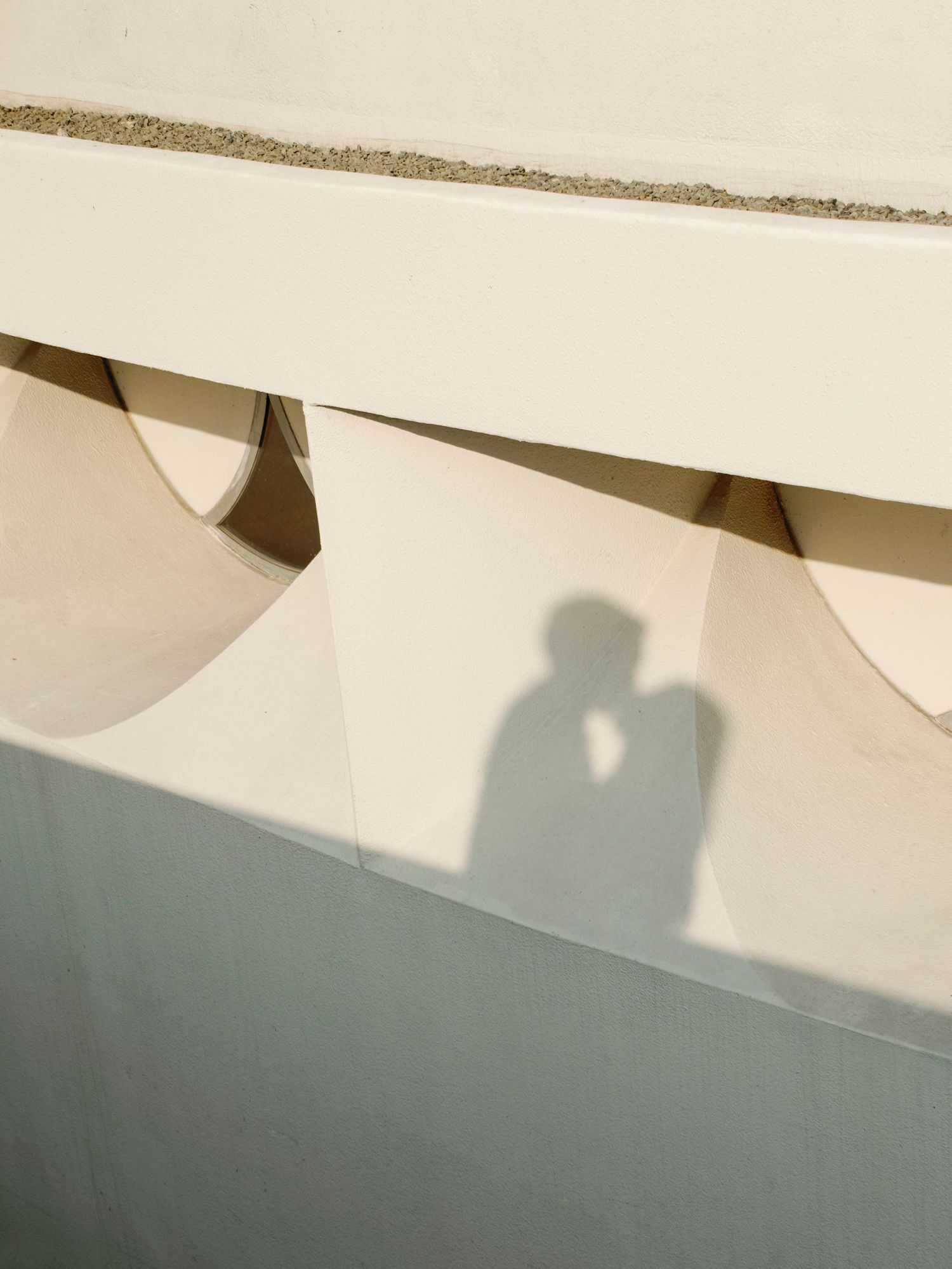 Minimalist architectural detail showing shadows on white wall surface.