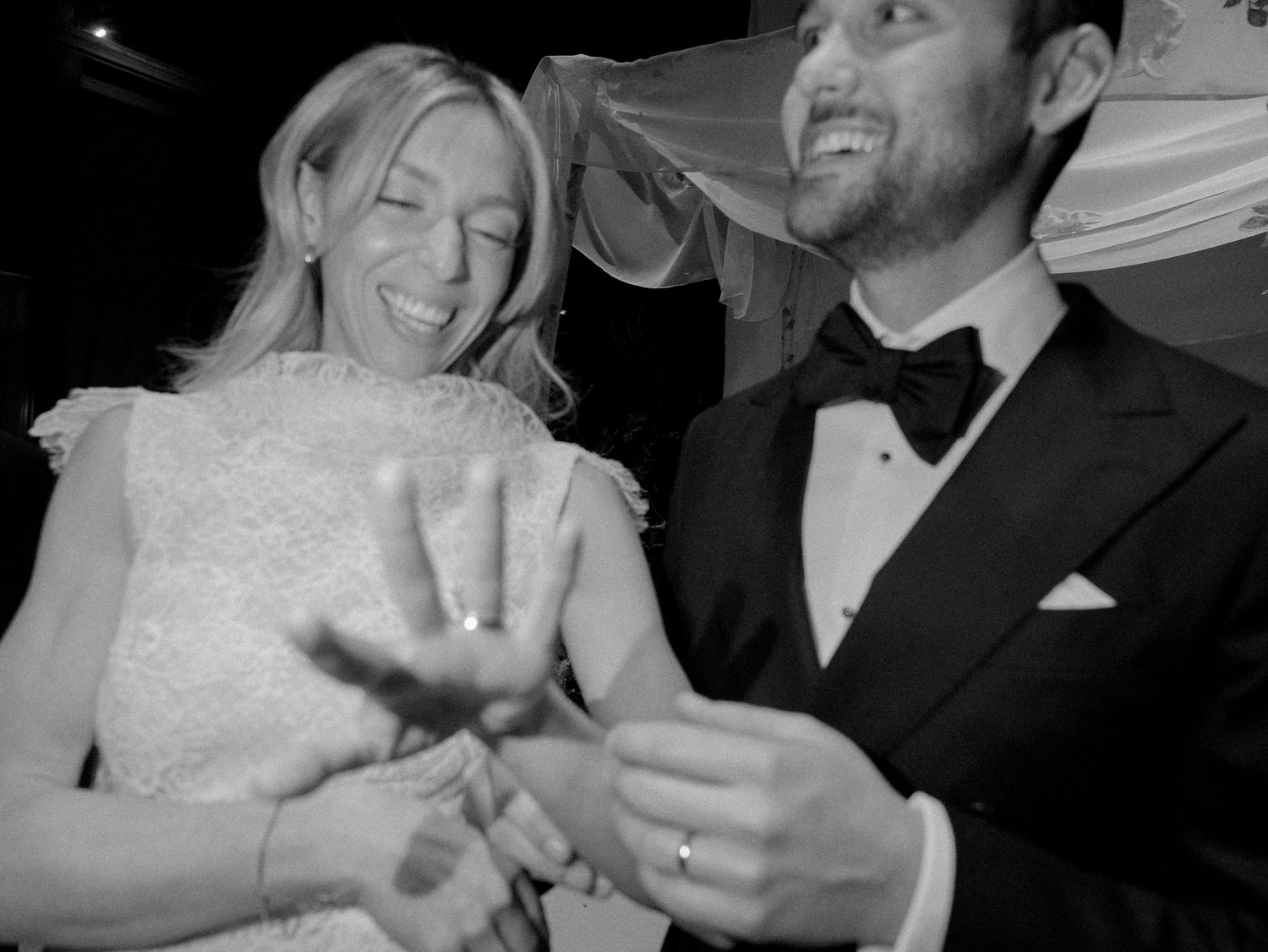 Candid moment of joy and laughter between a couple in formal wedding attire.