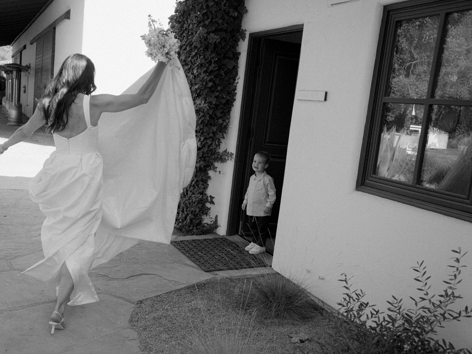 A flowing white wedding dress billows in the breeze during an outdoor photoshoot.