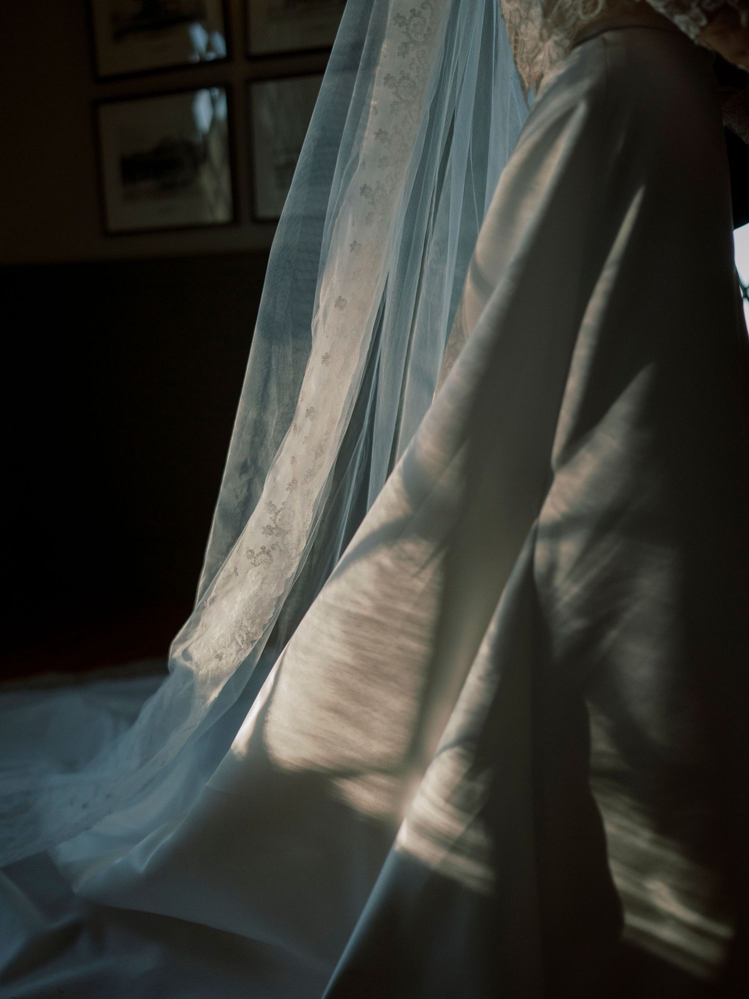 Close-up detail shot of delicate lace and tulle from a wedding dress in natural light.