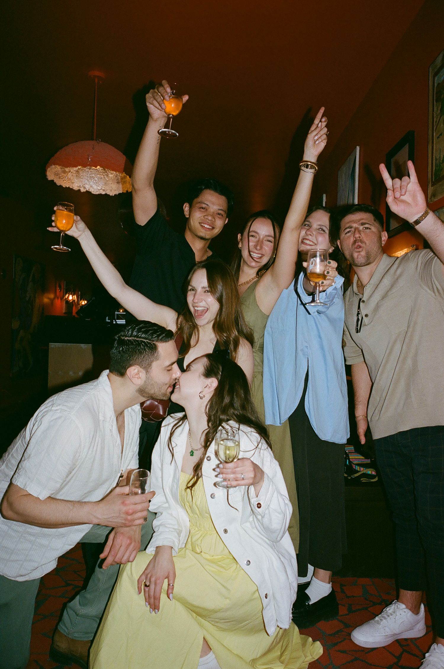 Party scene with people dancing and celebrating in a dimly lit room.