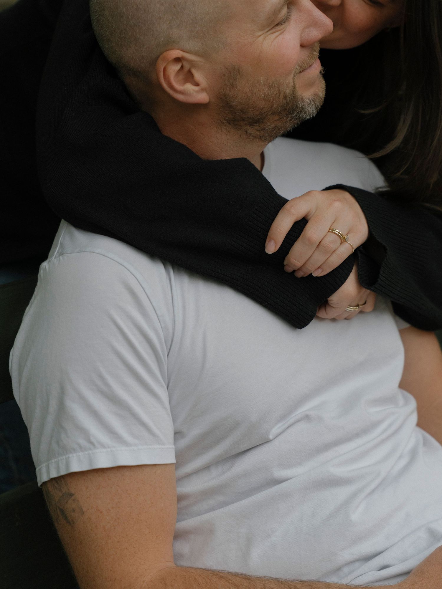 Close-up shot of two people embracing, one wearing a white t-shirt.