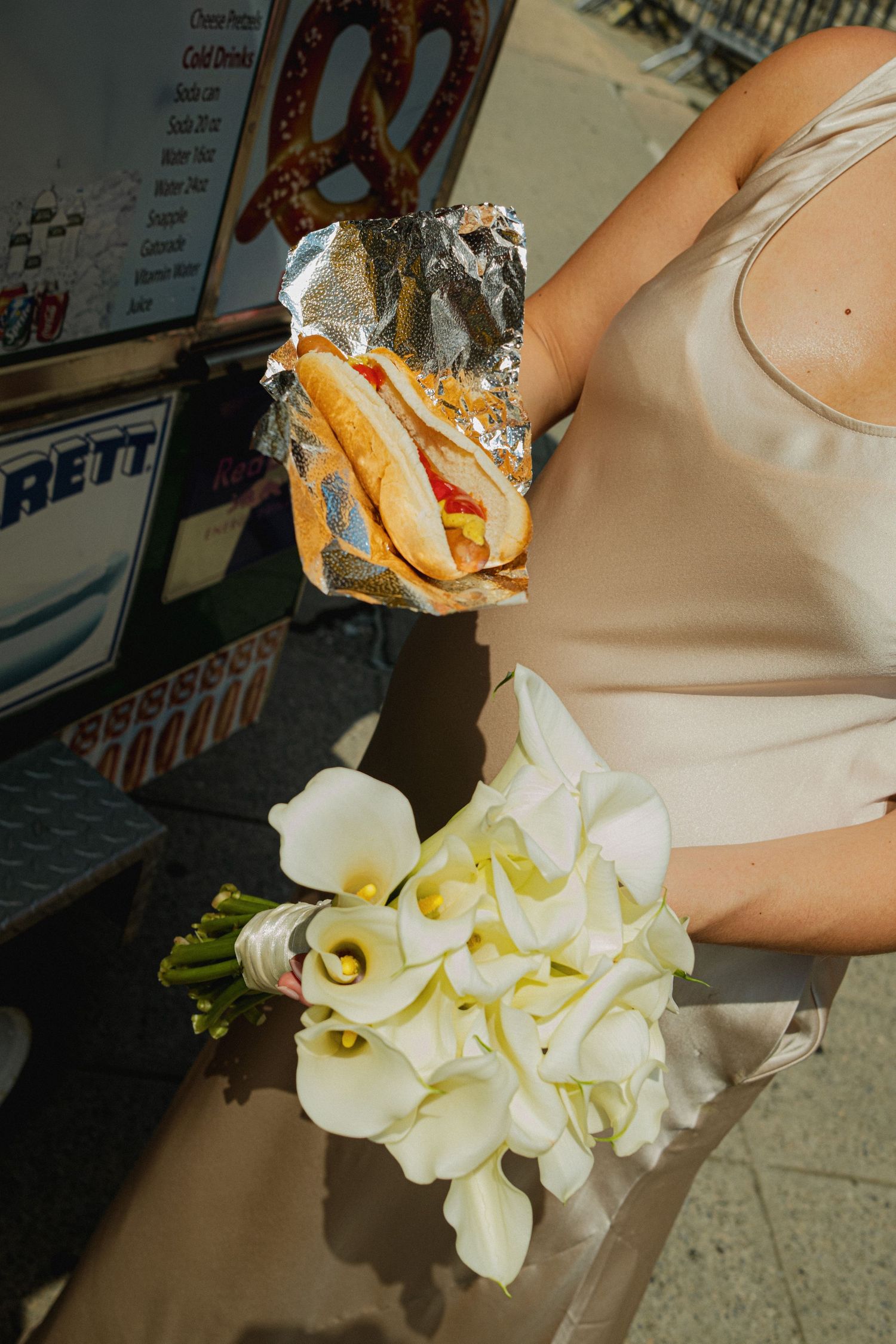 Close-up shots of white calla lily bouquet next to street food wrapped in foil.