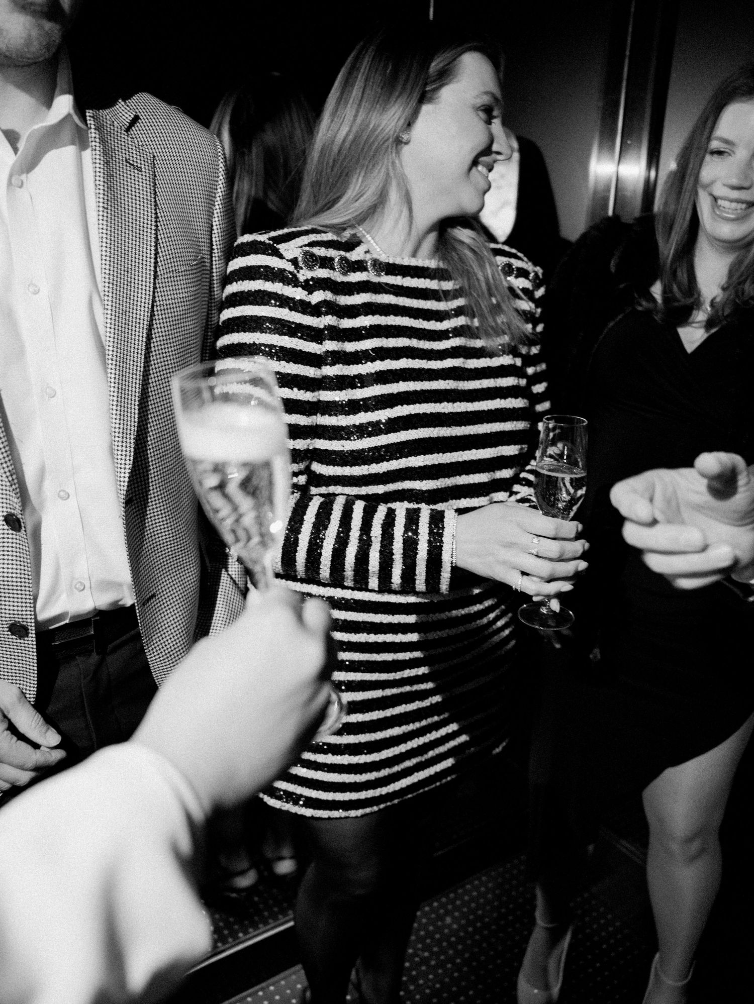 Party scene with guests in cocktail attire enjoying drinks and conversation.