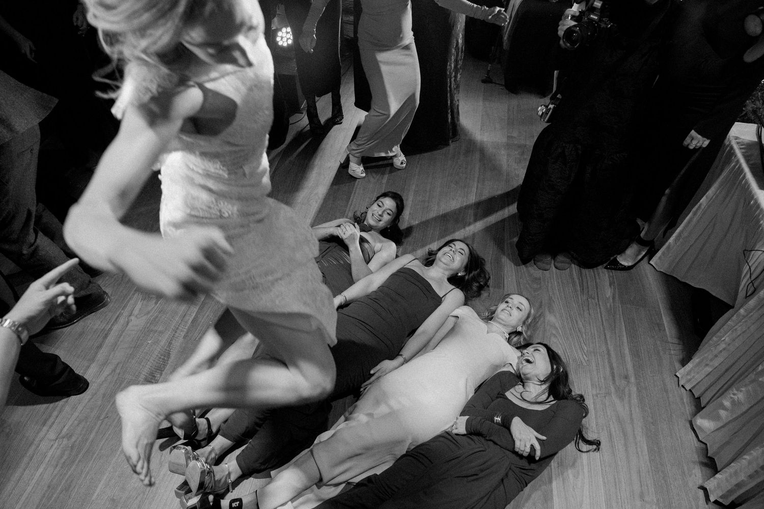 Black and white photo of wedding guests dancing at a reception.