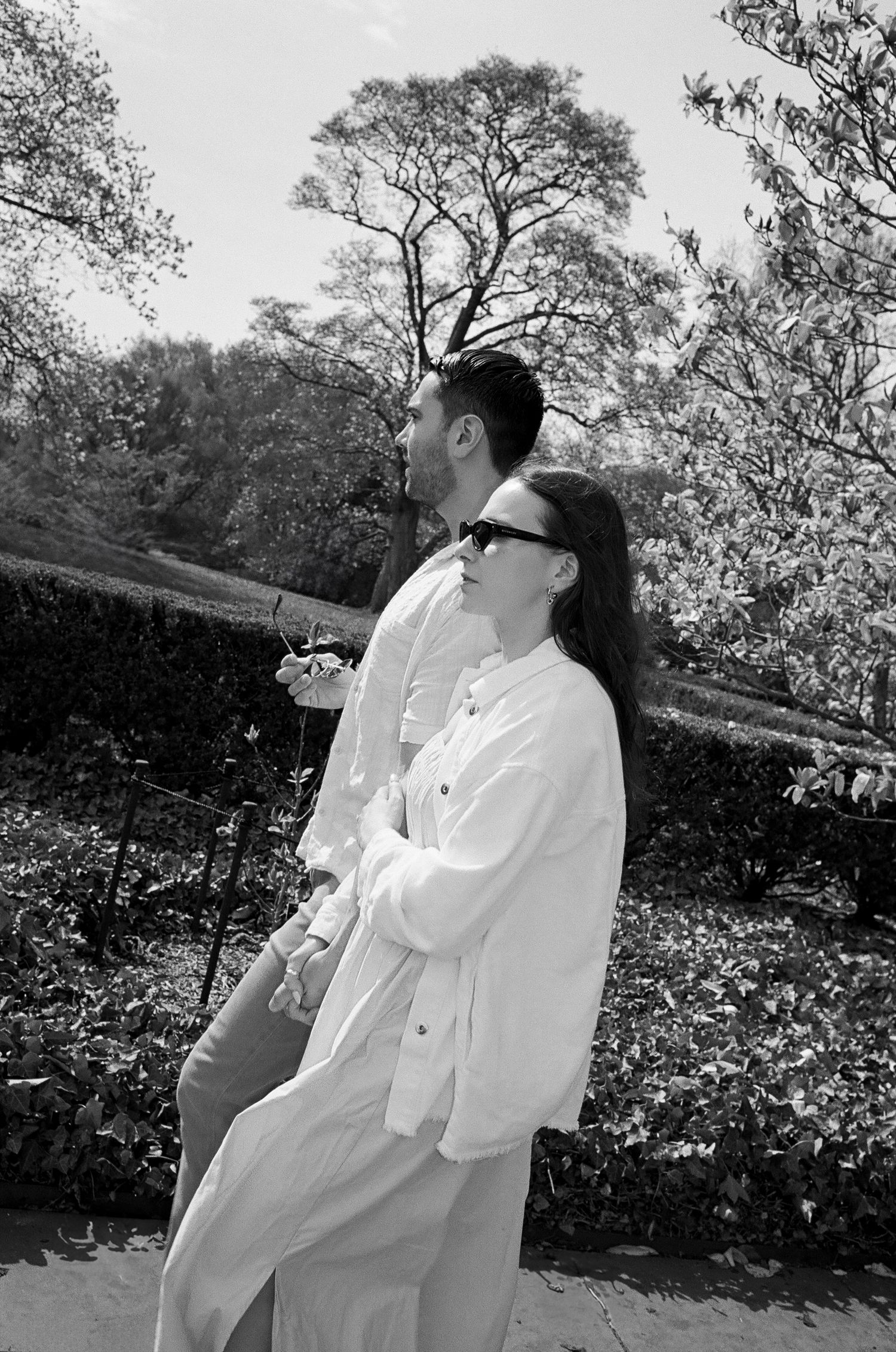 A black and white photo capturing a tender moment in a spring garden.