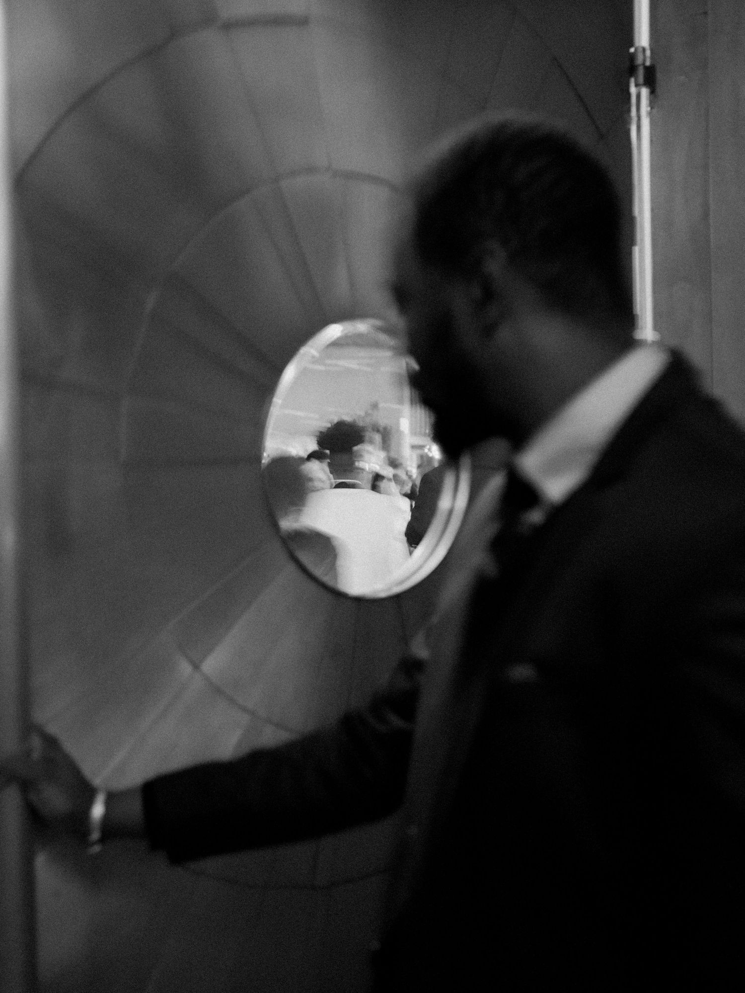 An artistic black and white photograph showing a reflection through a circular window or mirror.