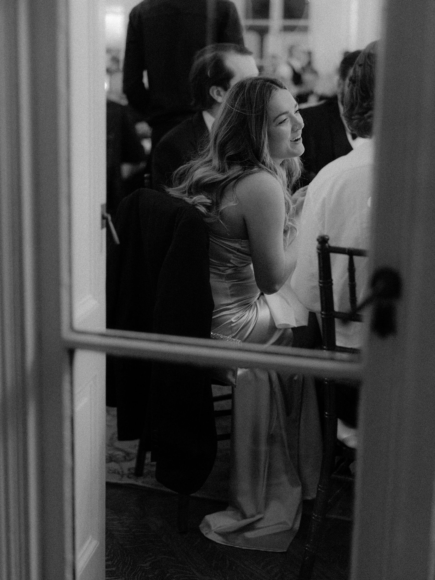 Candid black and white shots through doorways at an elegant indoor venue.