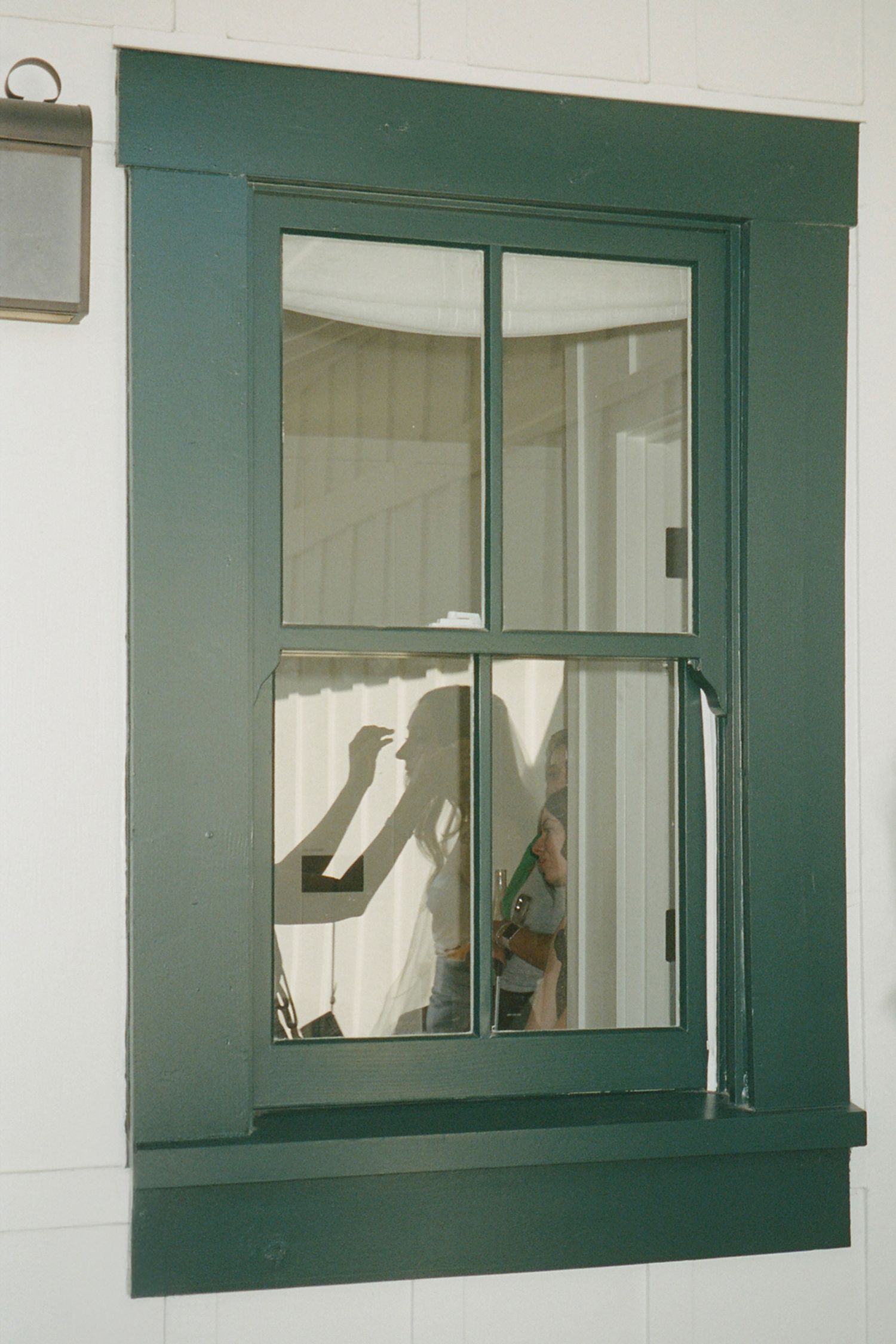 Green-framed windows with white interior walls create an architectural pattern.