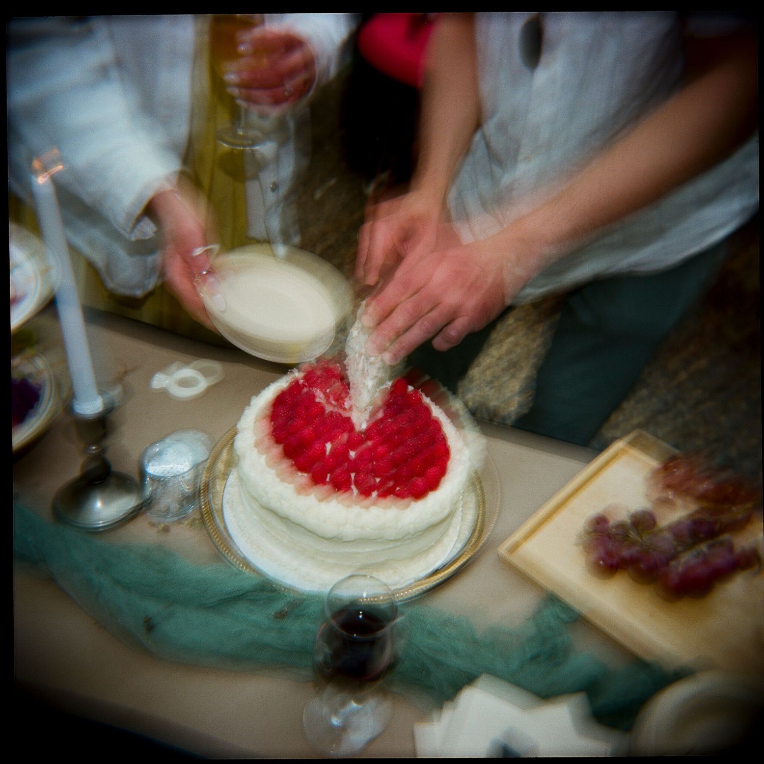 A series of photos showing someone decorating a cake with red frosting.