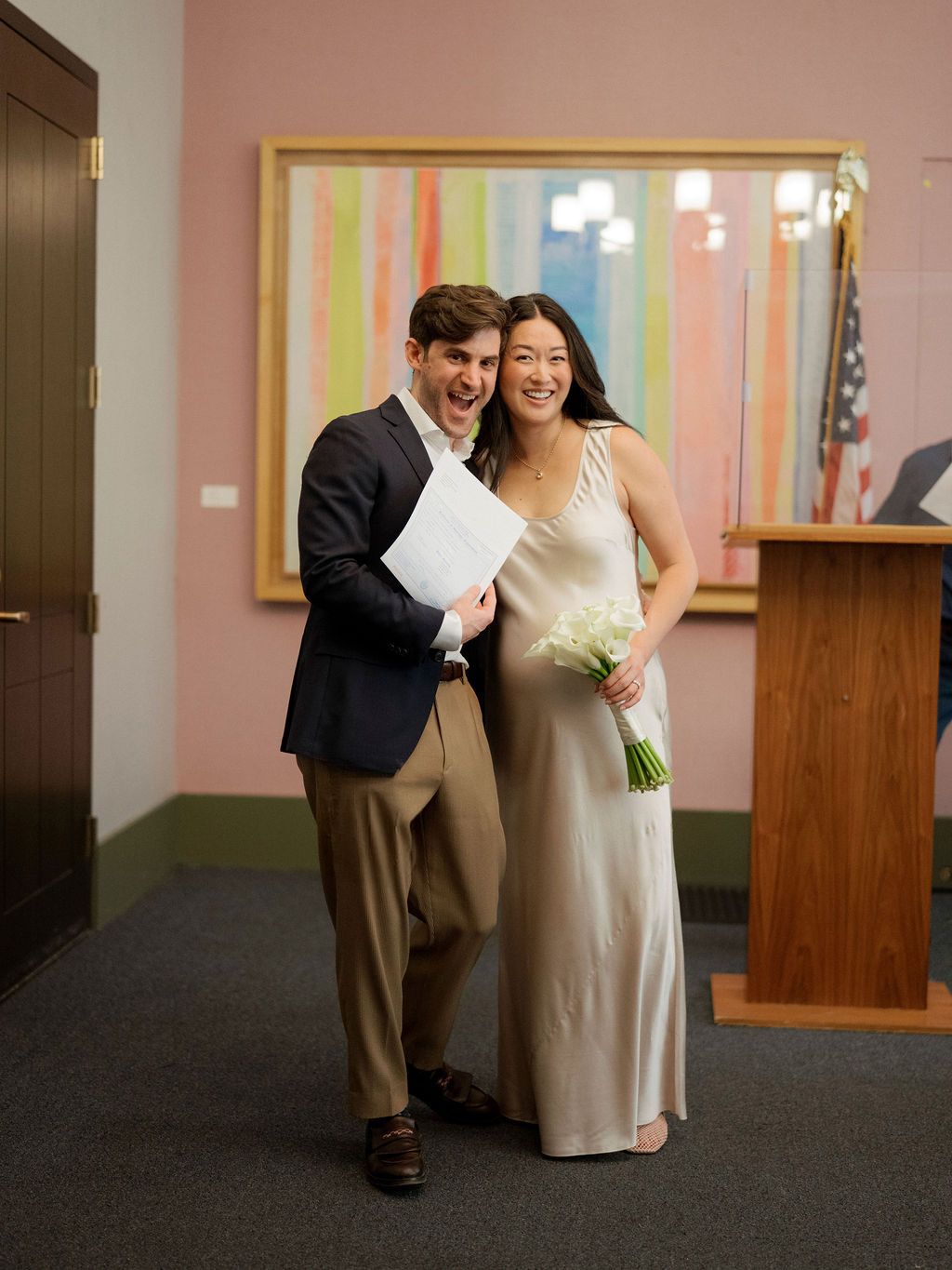 Candid shots in a hallway with pink walls showing joyful interactions between two people.