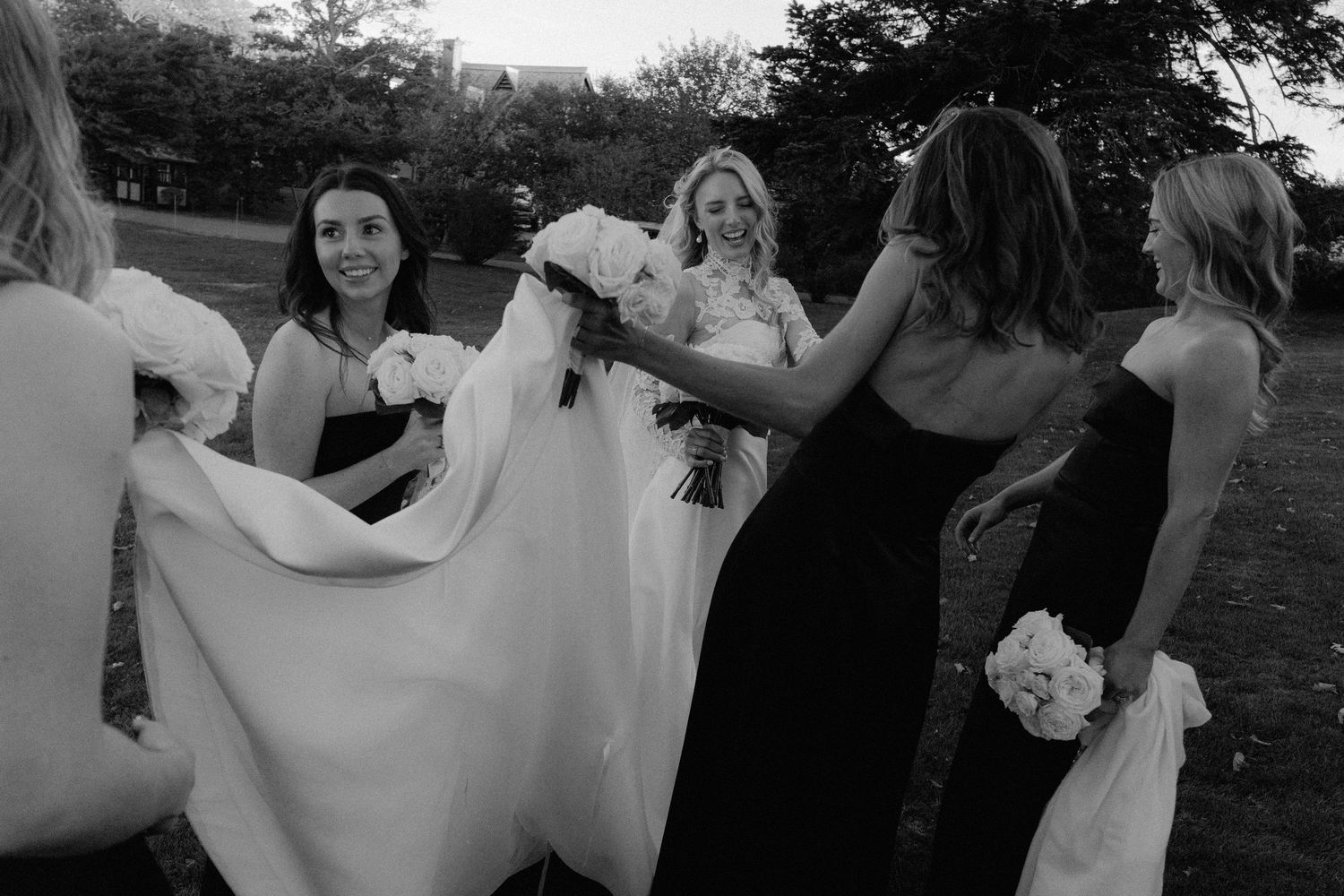Wedding guests form a circle while dancing and celebrating outdoors.
