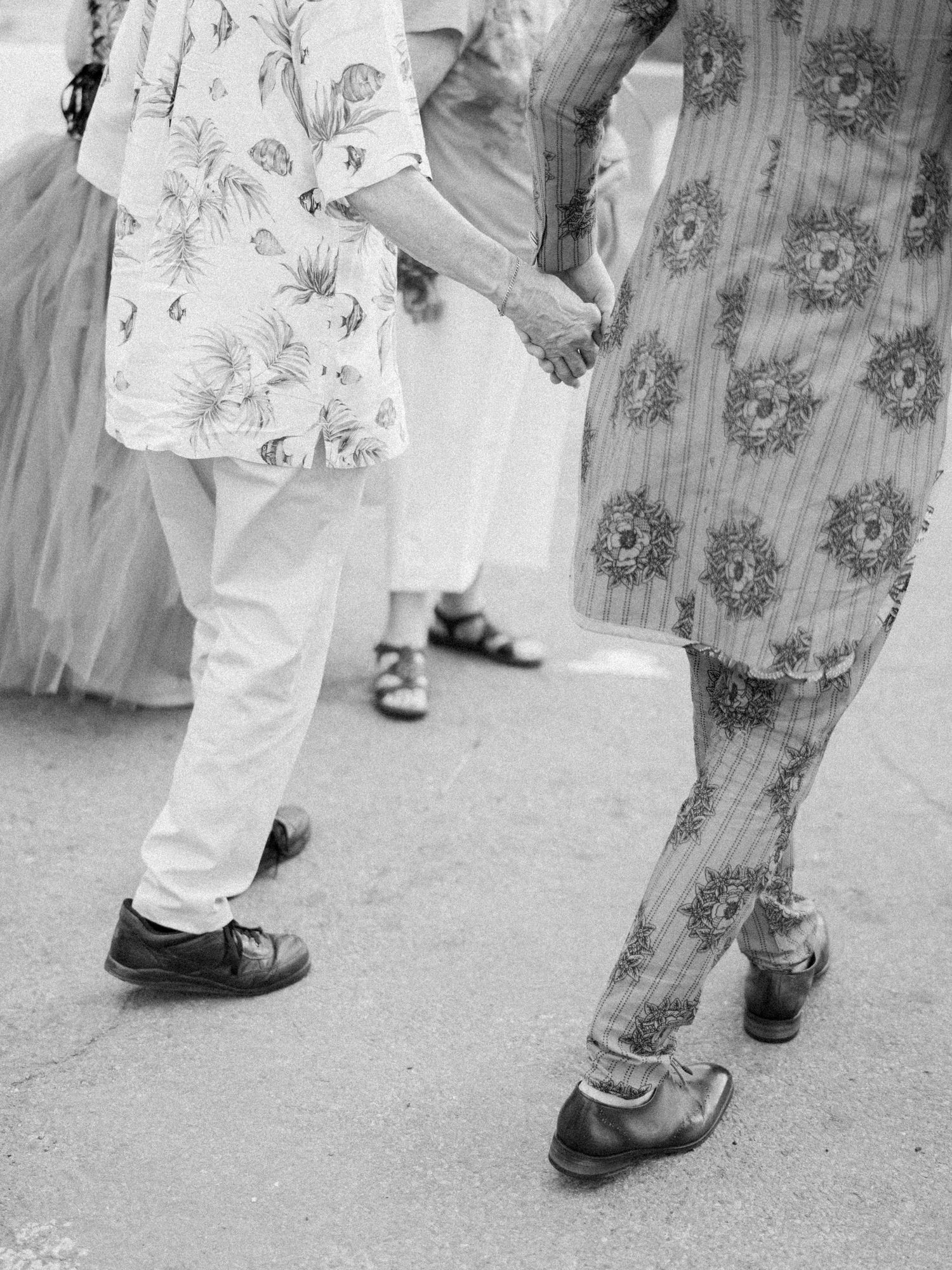Black and white photo showing vintage footwear and dancing feet on pavement.