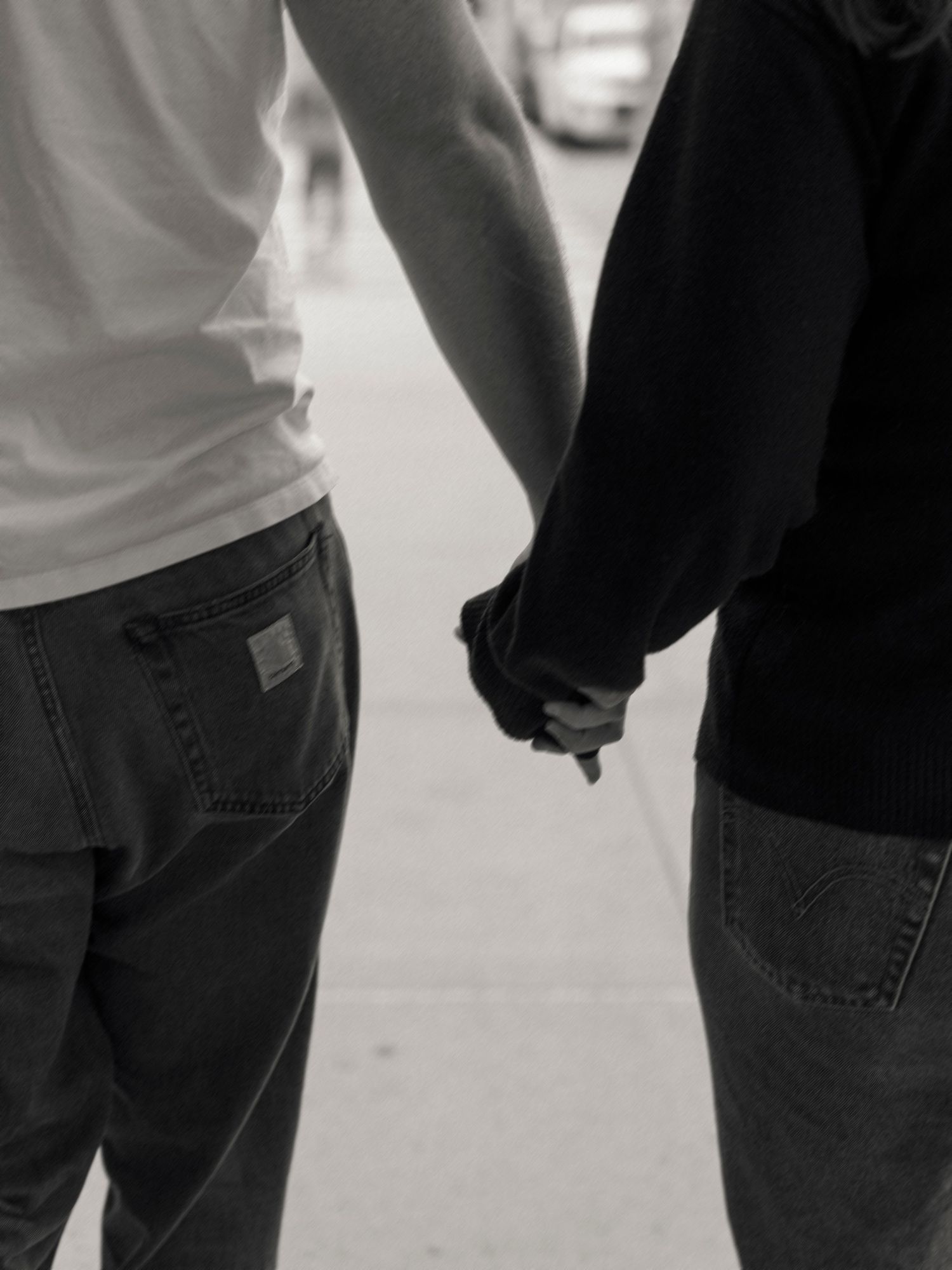 Two people holding hands in a black and white close-up shot.