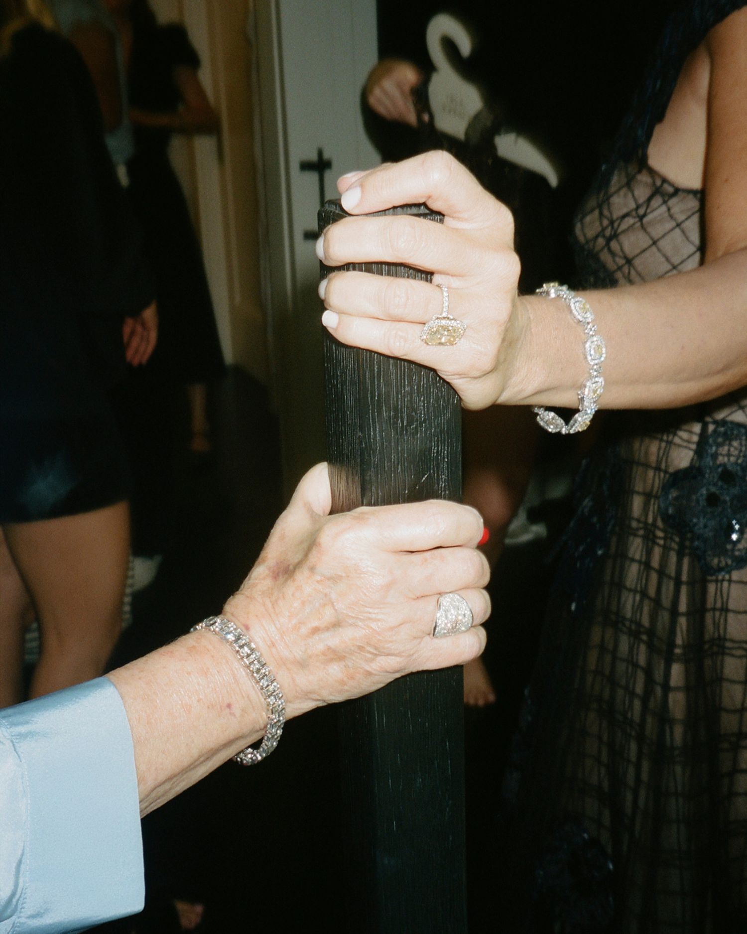 Close-up shots of hands with elegant jewelry and rings at a formal event.