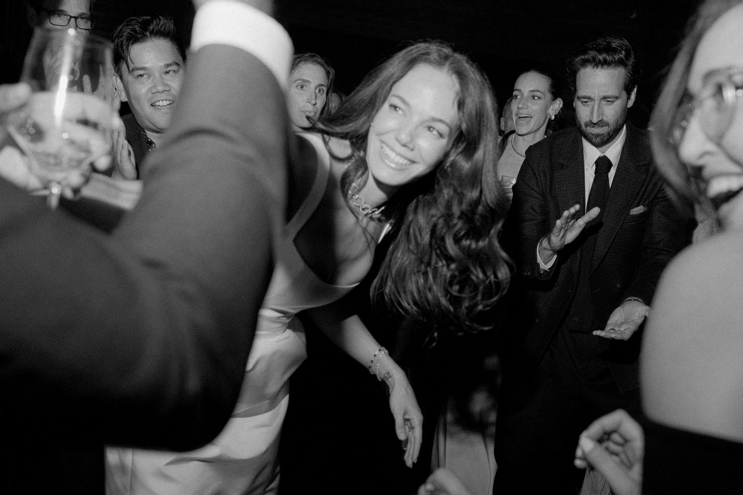 Black and white photo of a crowded dance party with people celebrating.