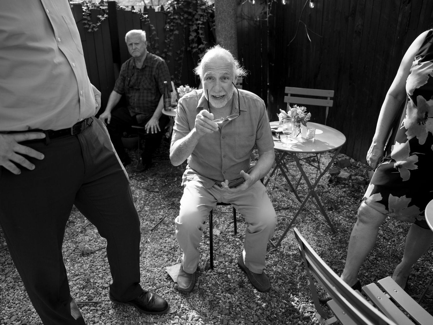 People gathered in backyard with folding chairs during casual outdoor event.