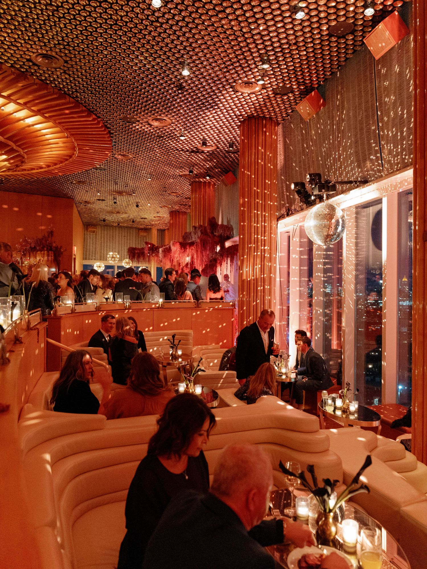 Elegant restaurant interior with curved seating and latticed ceiling lit by warm ambient lighting.