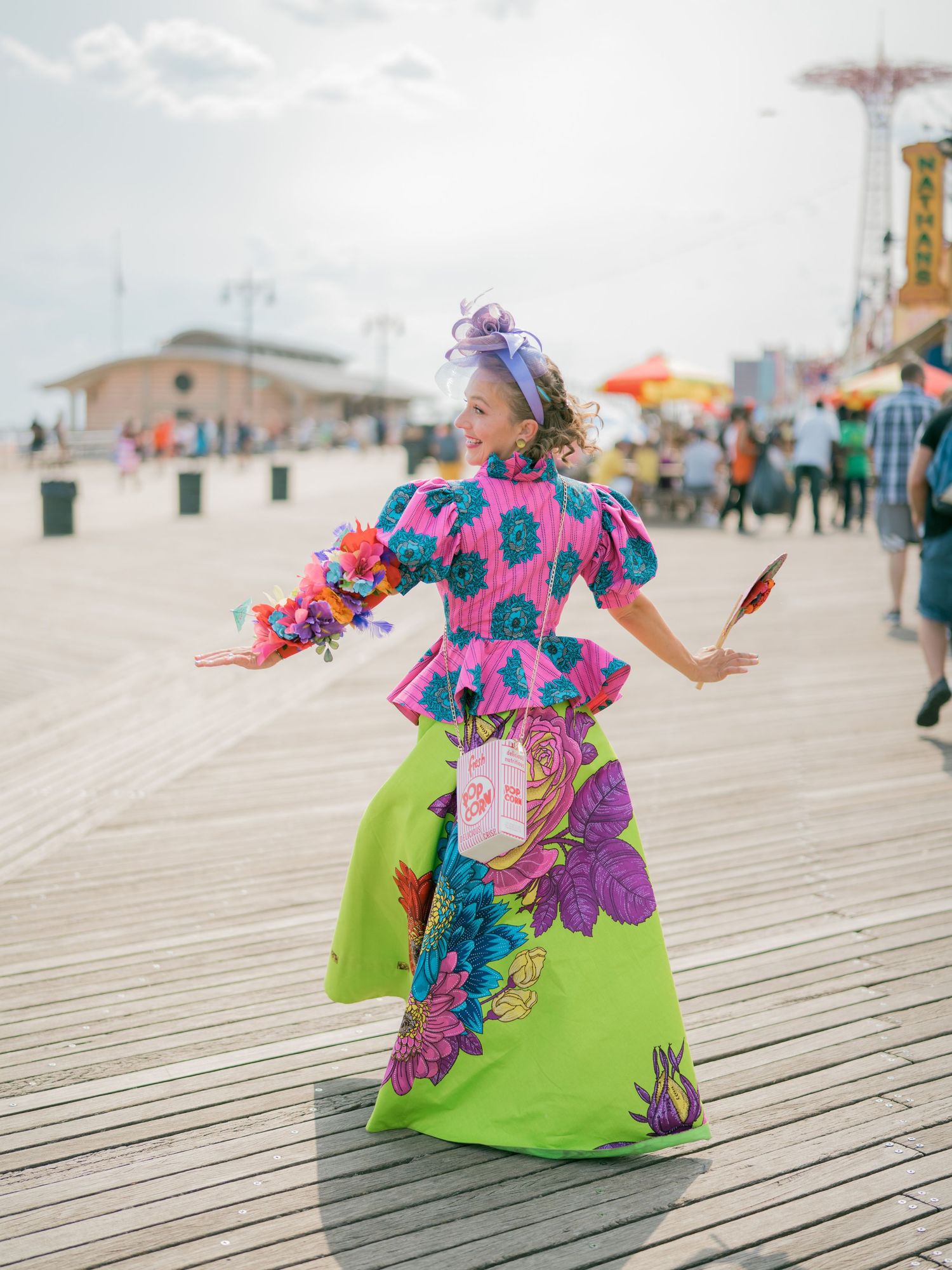 A whimsical dance performance on a wooden boardwalk with colorful vintage-inspired costumes.