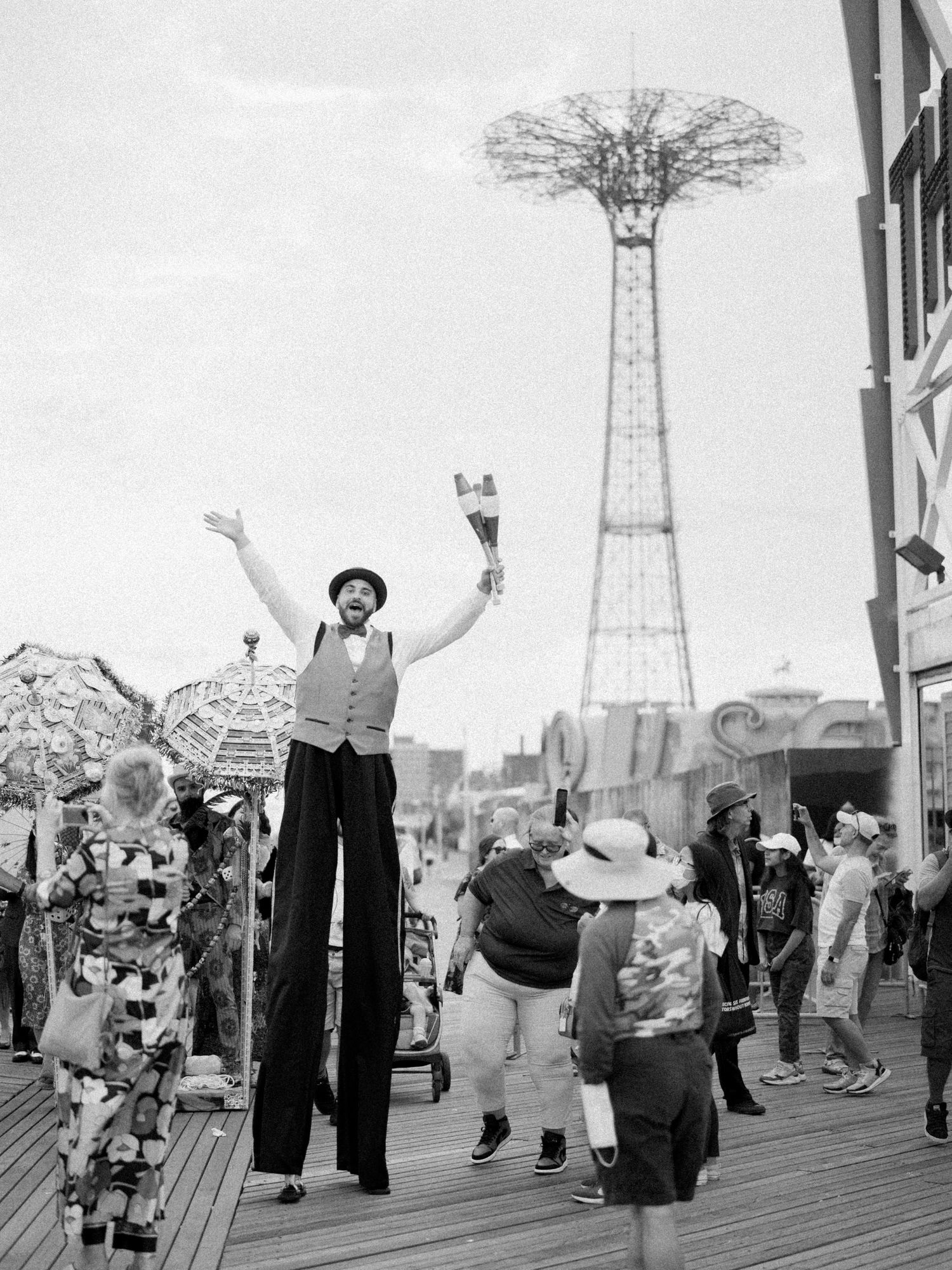 Black and white boardwalk scenes with vintage-dressed dancers and Coney Island tower.