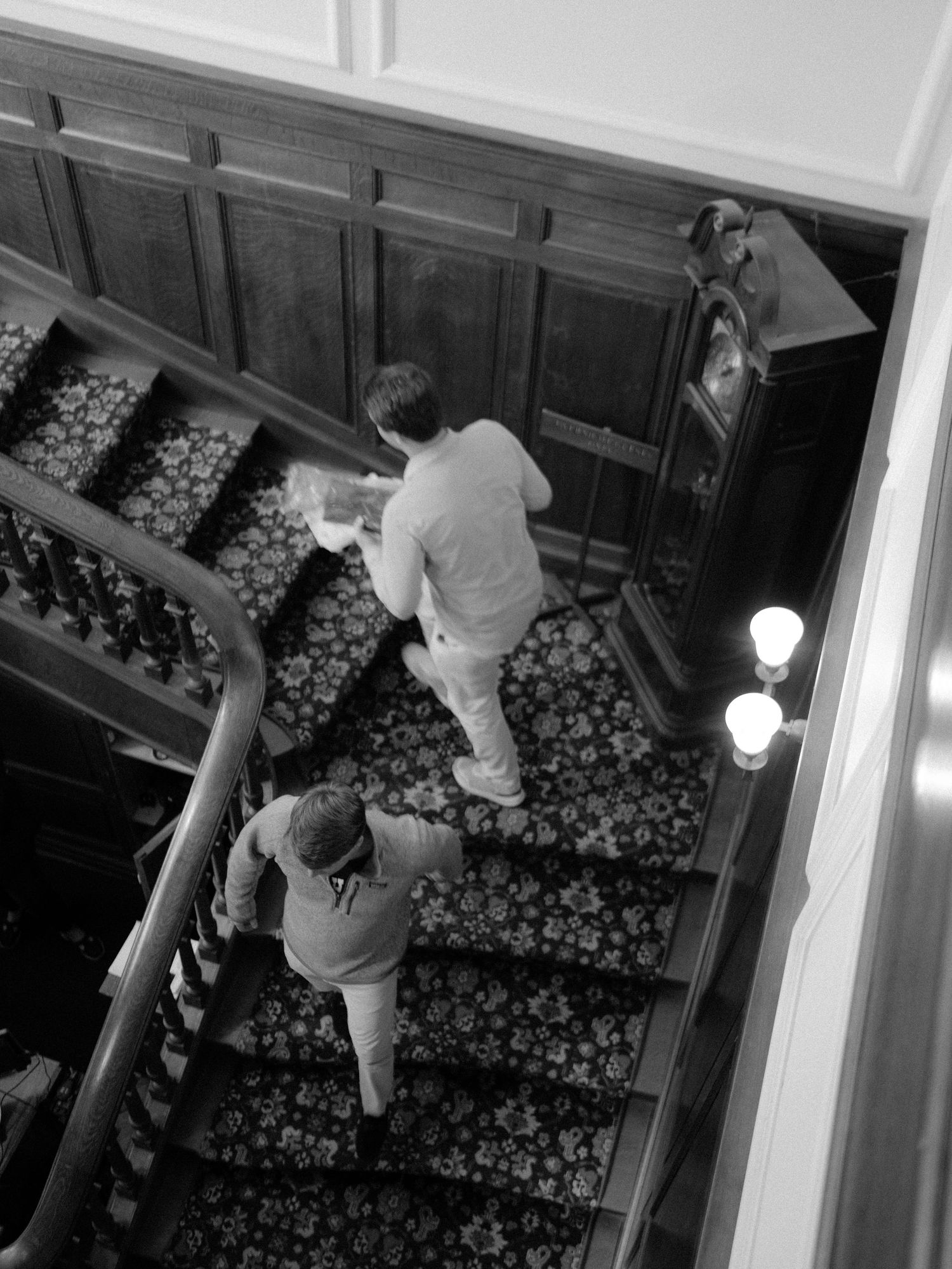Person climbing carpeted stairs in black and white photography.