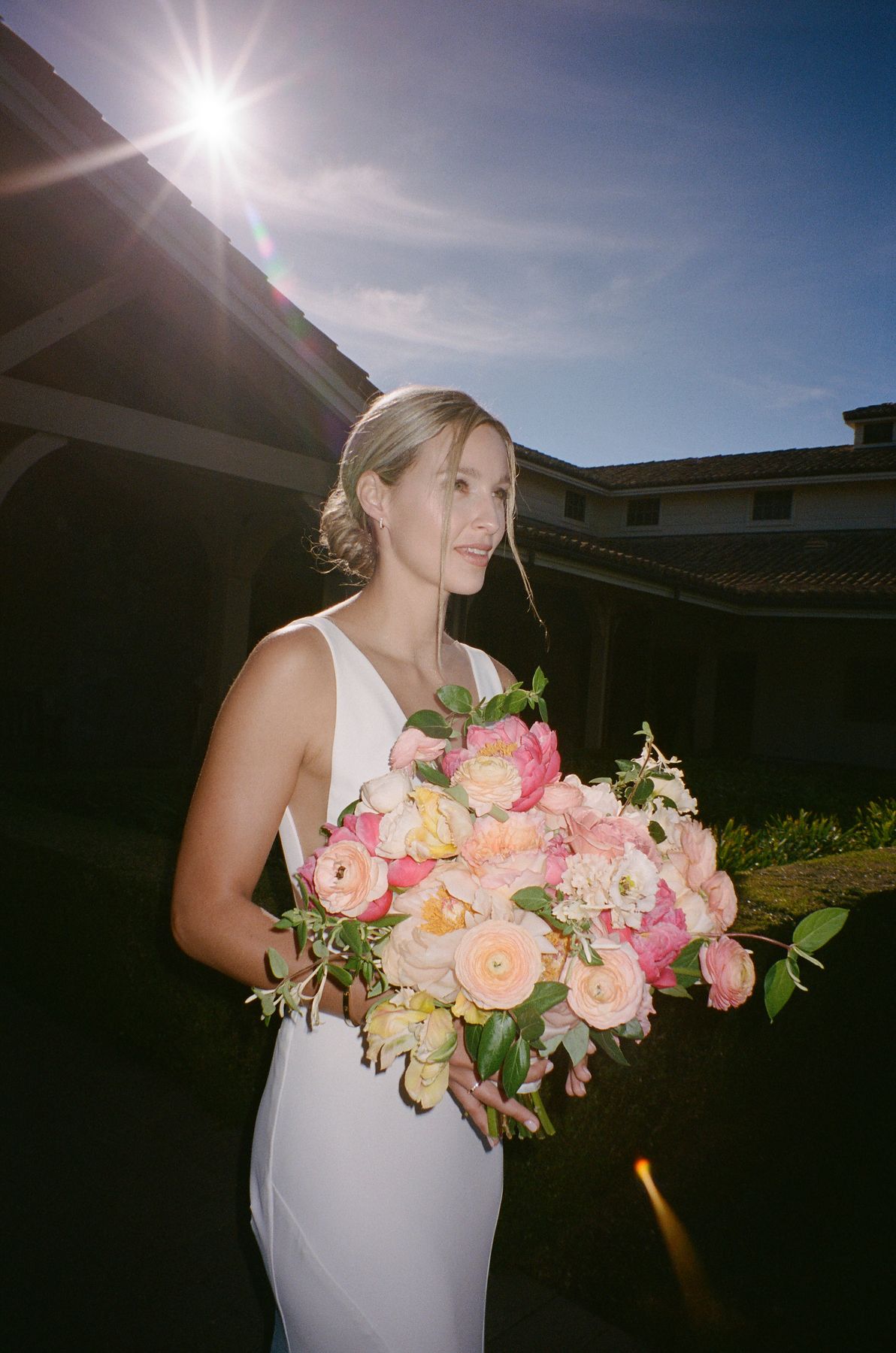 Beautiful pink and peach floral bouquet captured in golden sunlight outdoors.