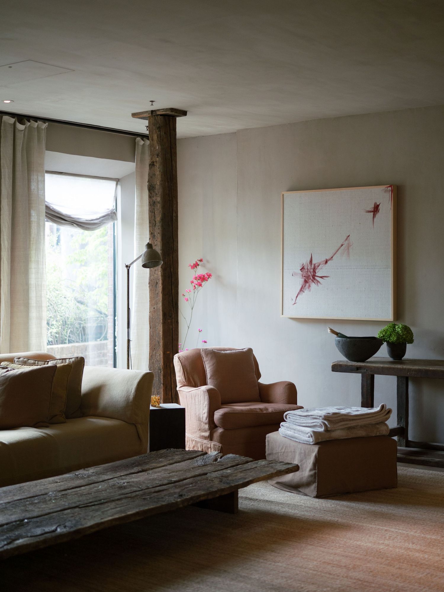 Minimalist interior room with brown leather chairs and abstract art on white walls.
