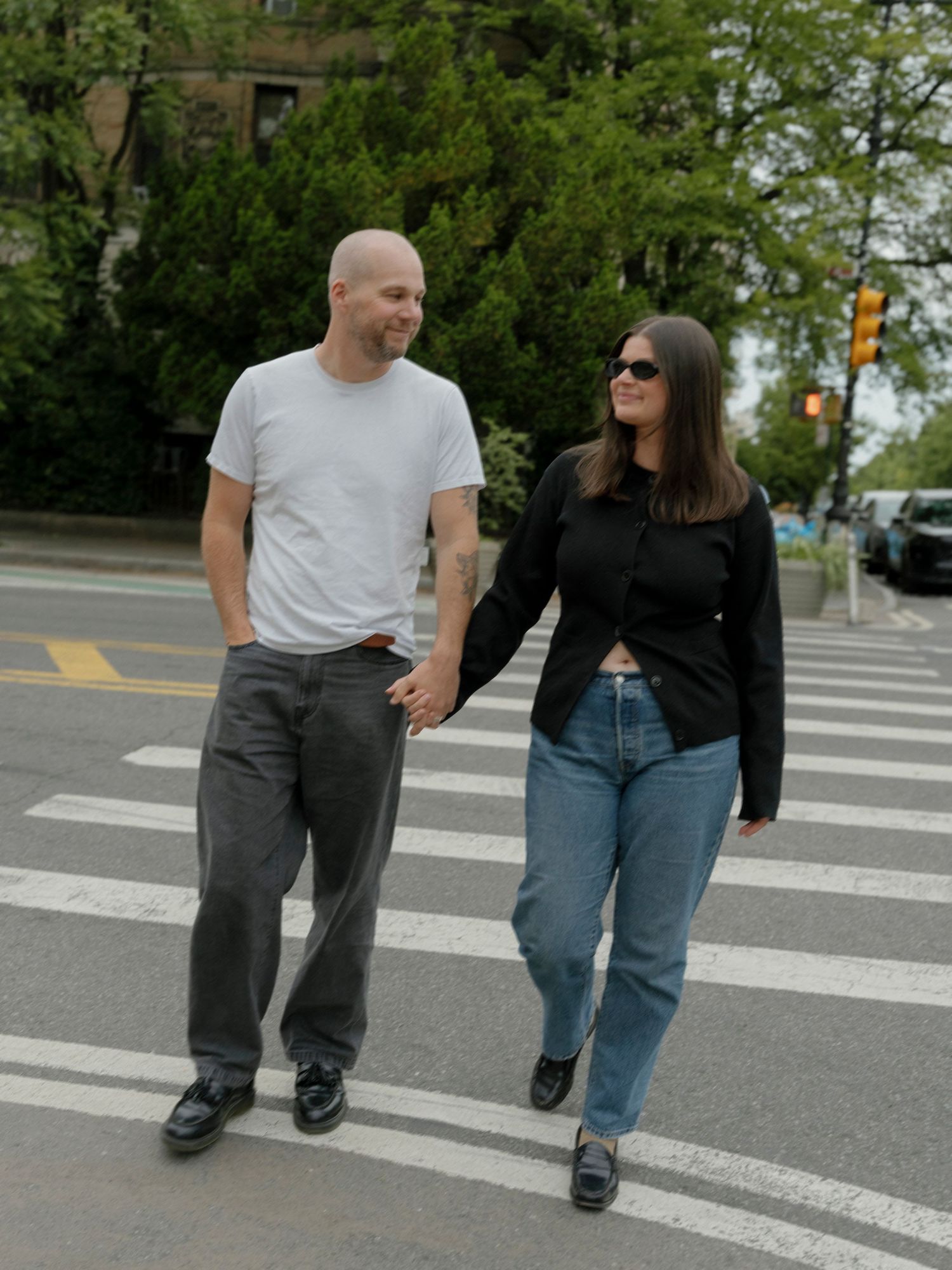 Couple walking together on crosswalk in casual clothing.
