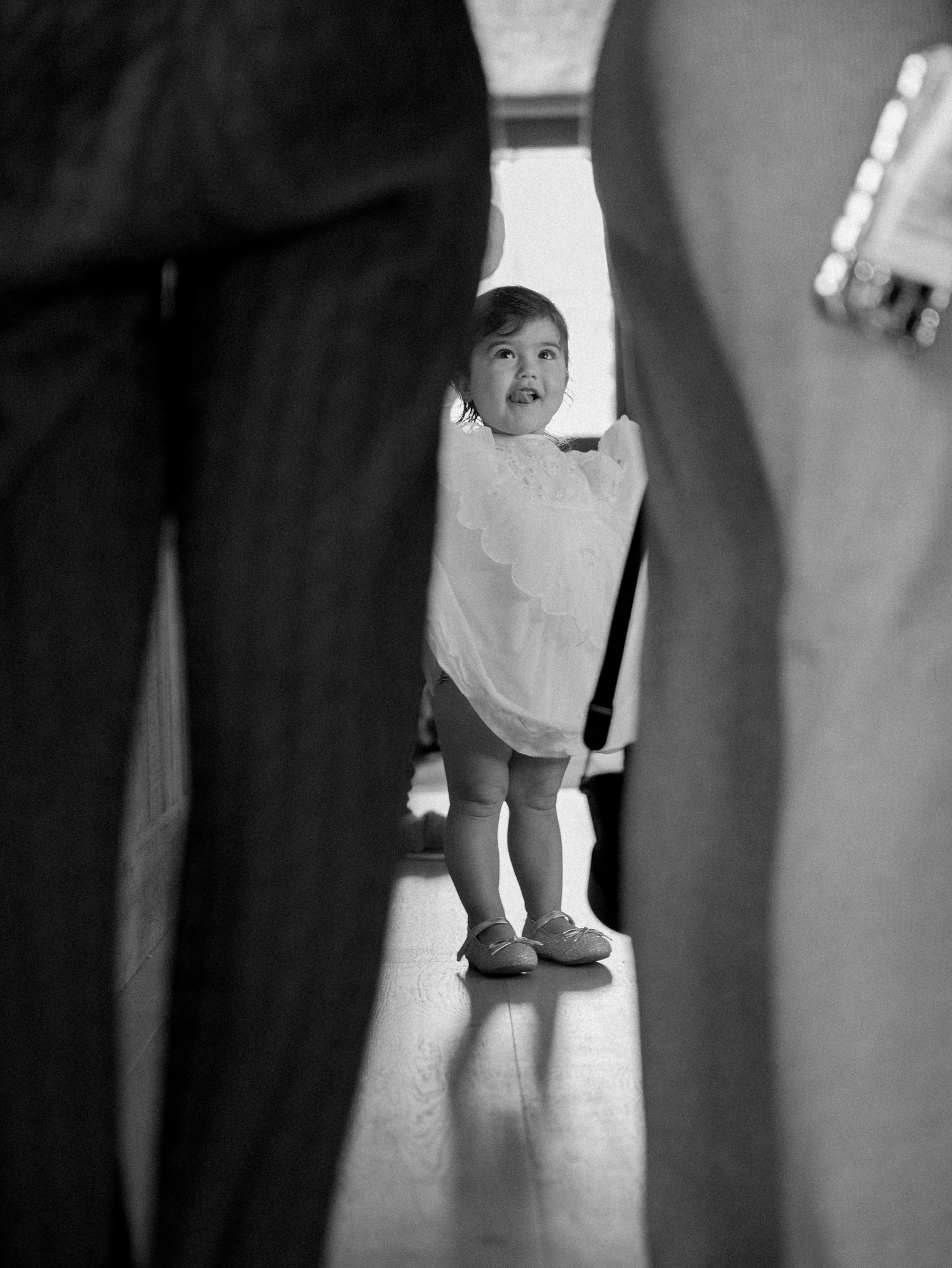 Black and white photo series showing a small child walking between adults in formal attire.