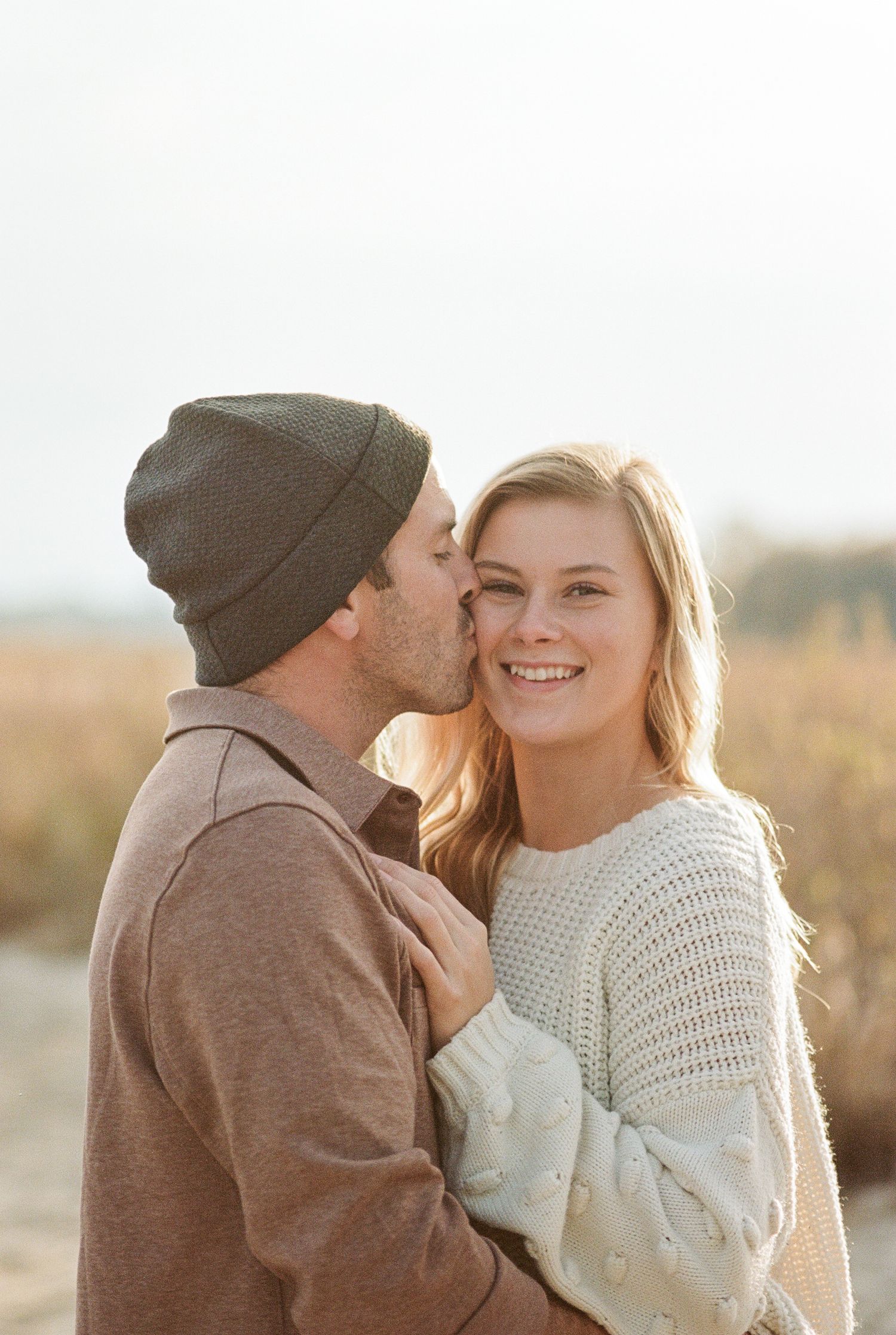 Engaged couple walking hand-in-hand at Norfolk waterfront by Norfolk photographer