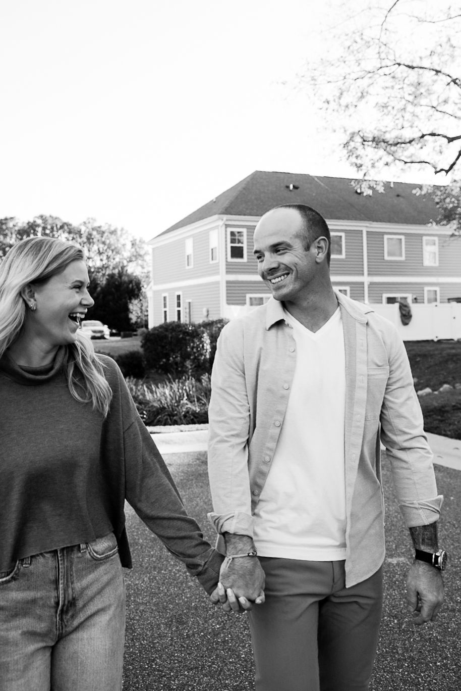 Engaged couple walking hand-in-hand at Virginia Beach waterfront by Norfolk photographer