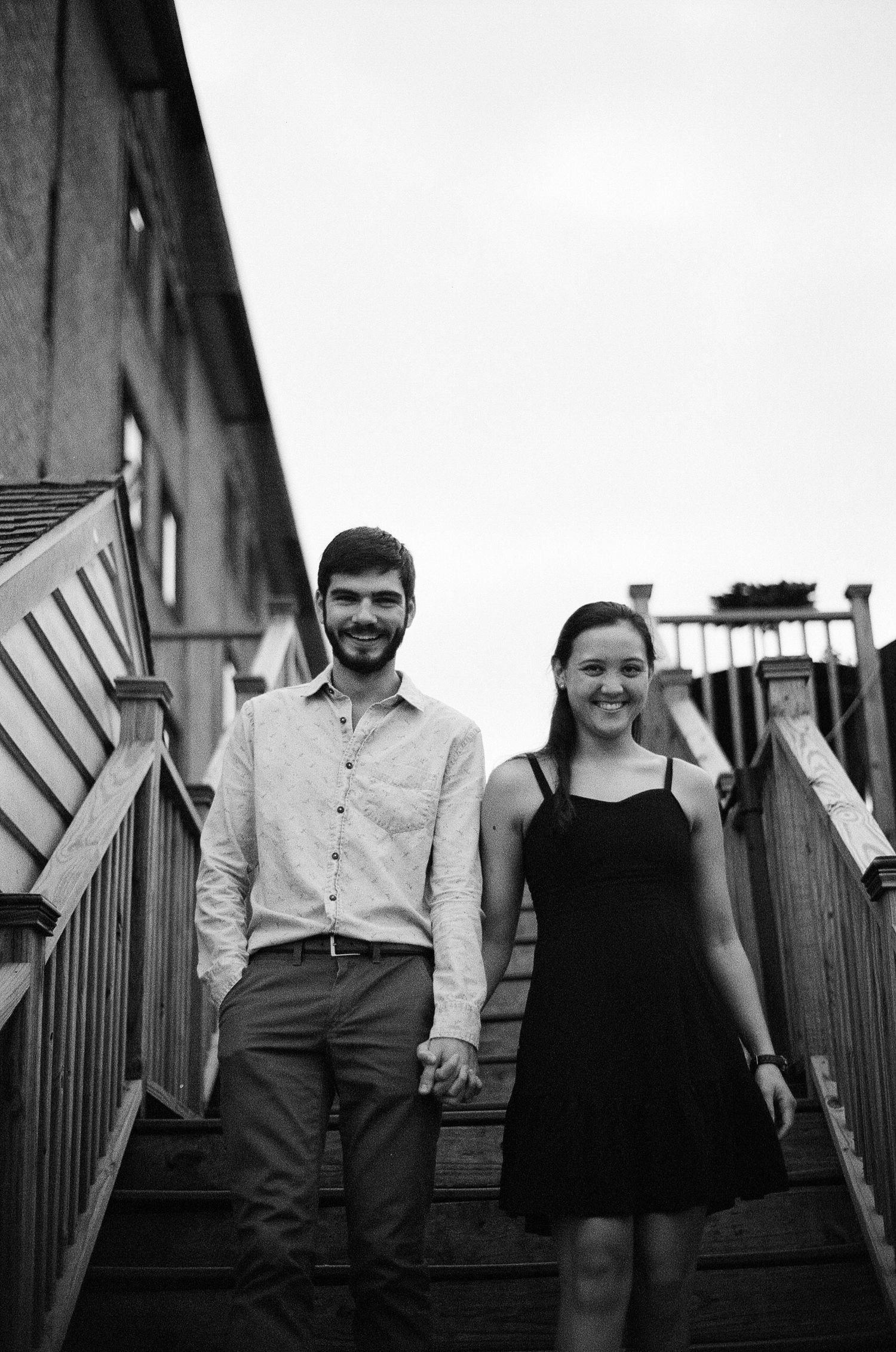 Engaged couple walking hand-in-hand at Norfolk waterfront by Norfolk photographer