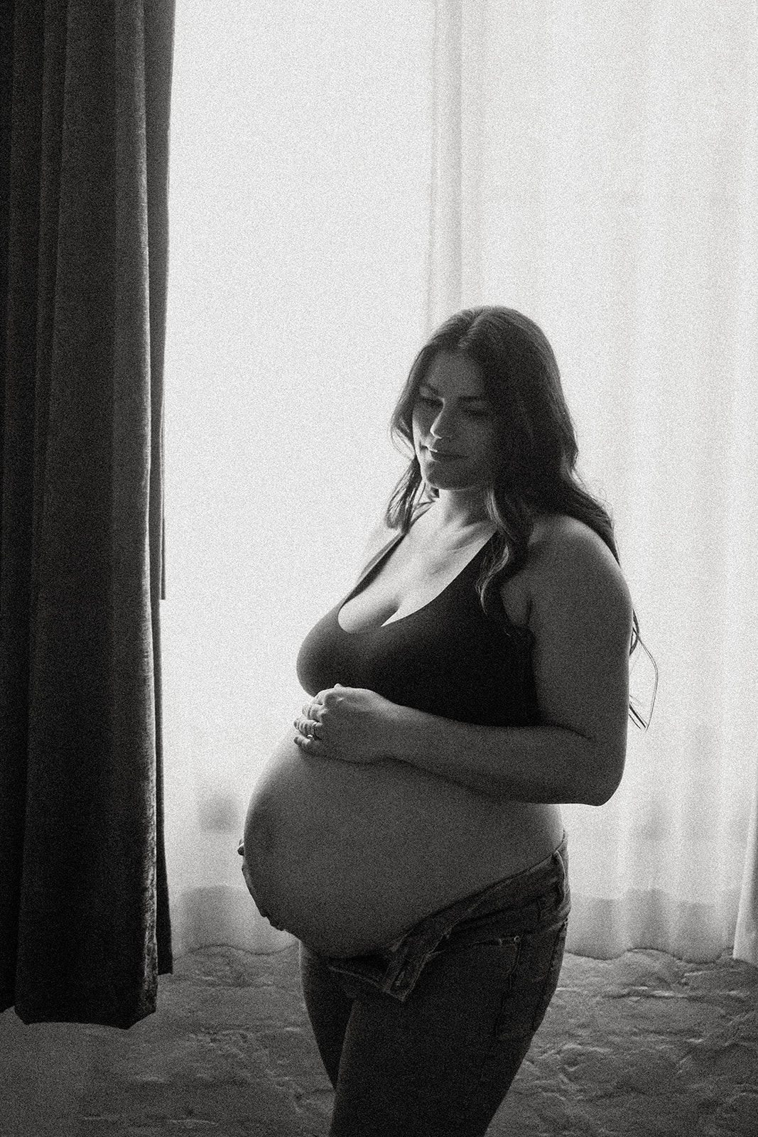 Black and white intimate maternity portrait in natural window light.
