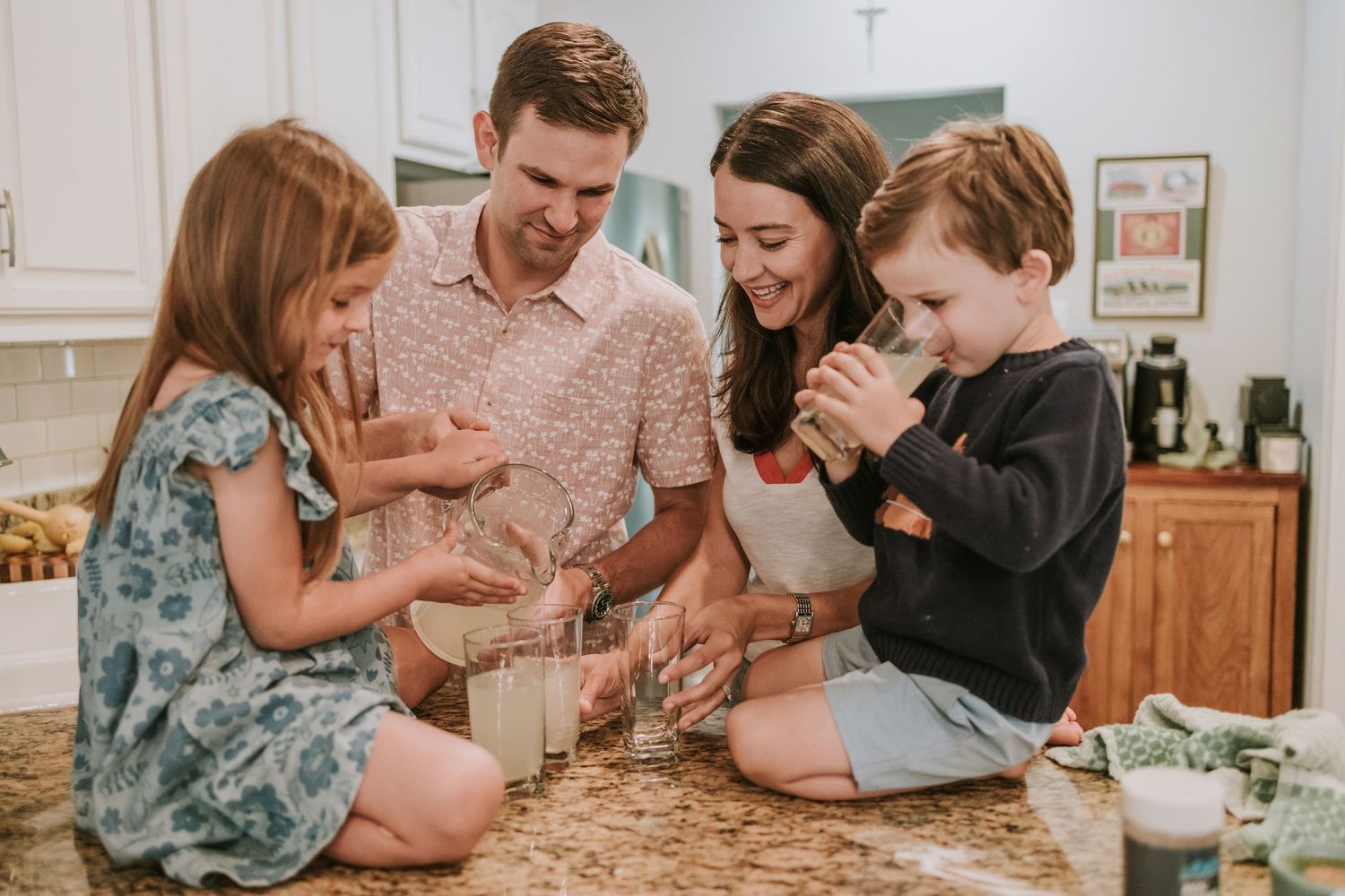 A group enjoying a casual moment together in a kitchen while baking and mixing ingredients on a counter.