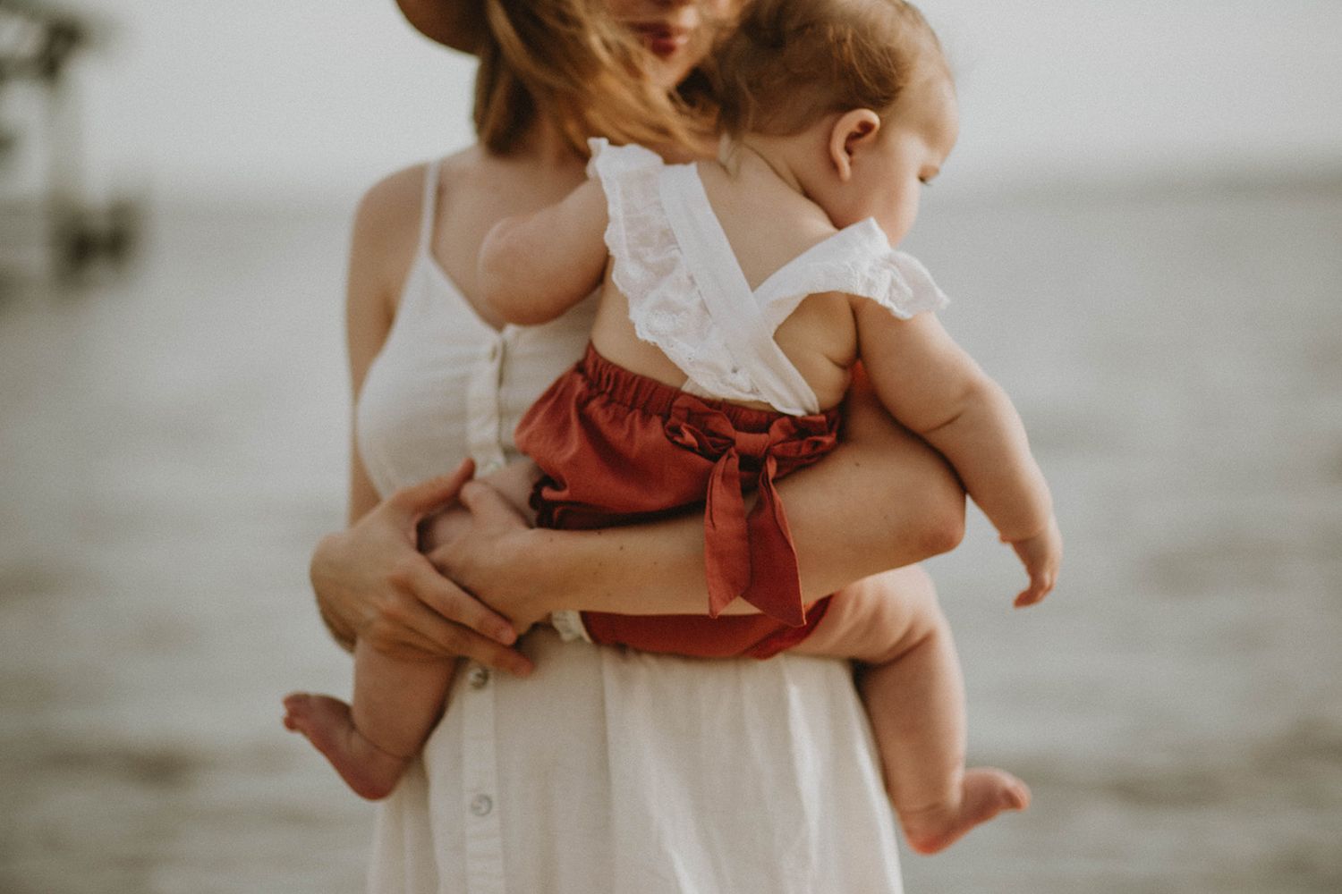 A gentle embrace by the water, captured in soft evening light.