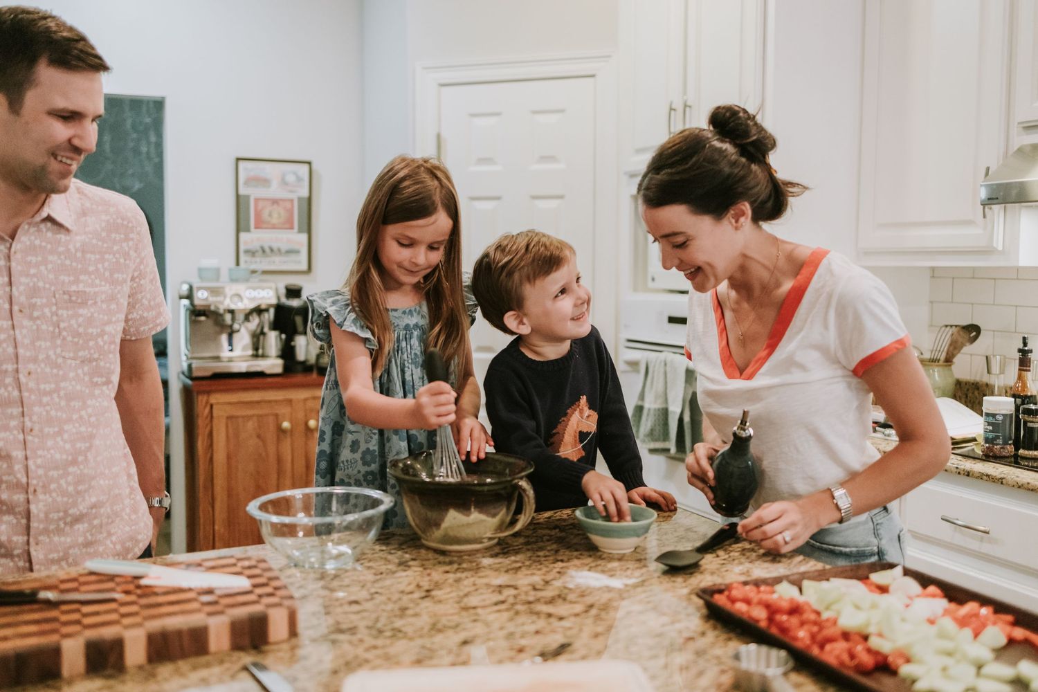 A group works together in a bright kitchen to prepare fresh food and baked goods during a cooking class.