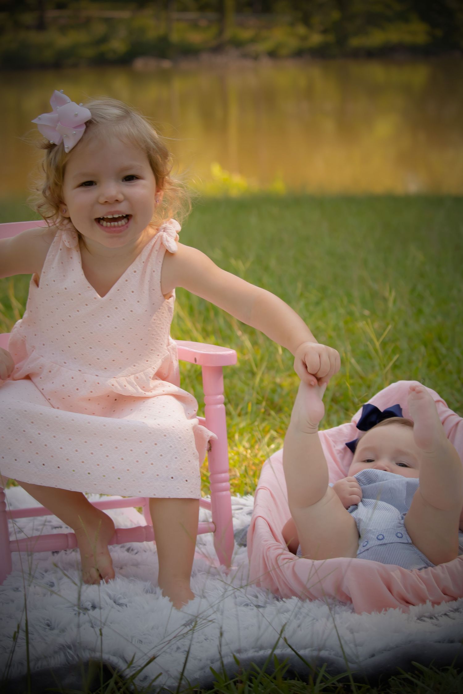 big sister holding baby sisters foot
