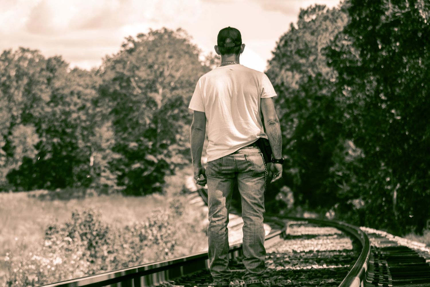 man standing on railroad tracks