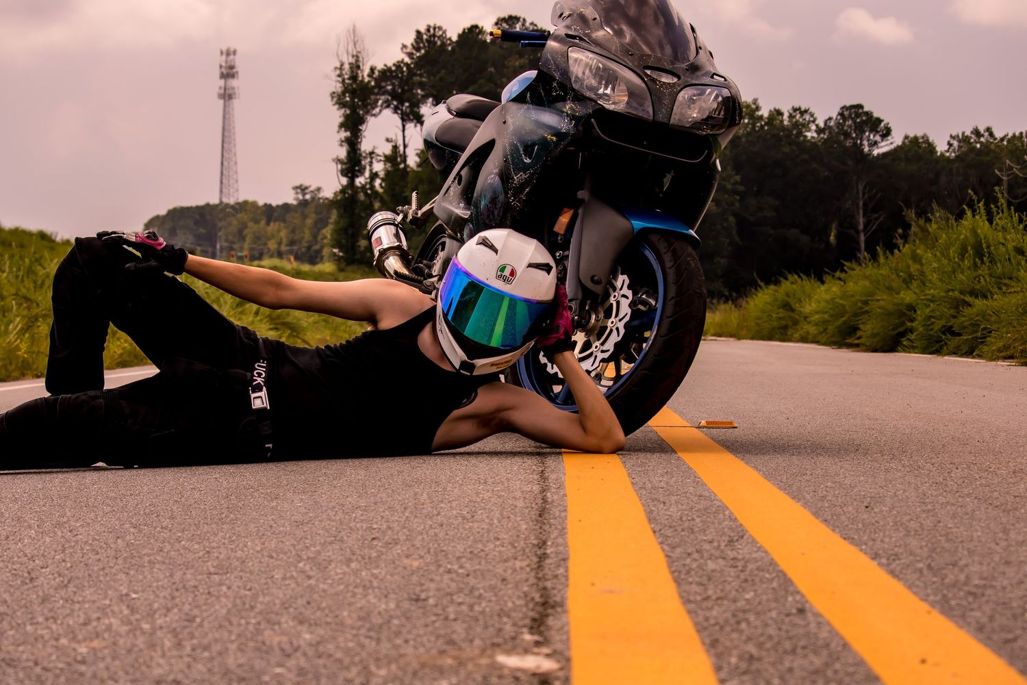 Young boy posed near motorcycle on two-lane road with golden light