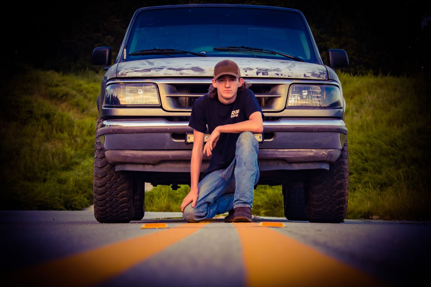 Boy squatted down in front of vintage truck on double yellow lines during a mini session