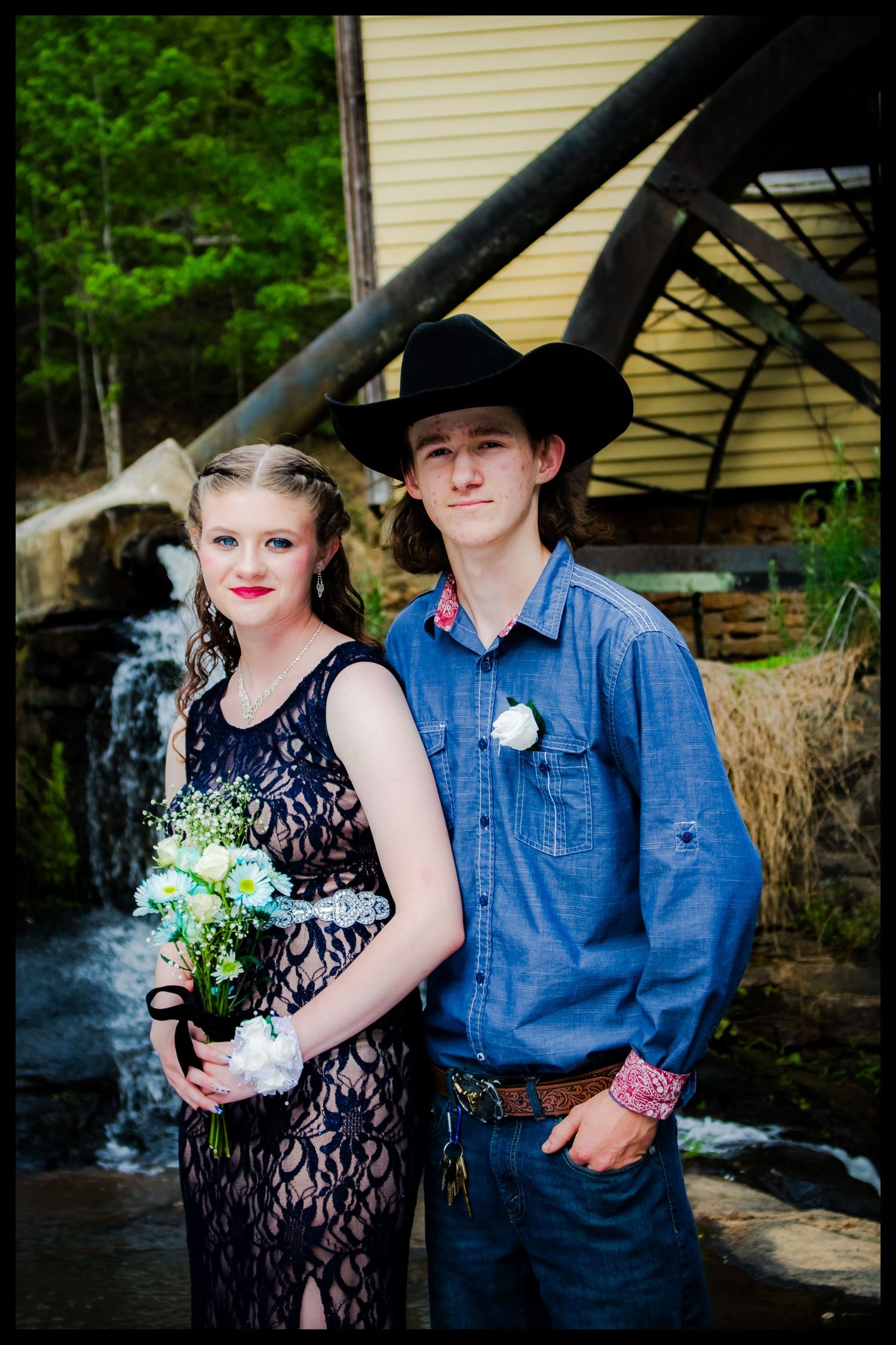 prom couple in front of water wheel