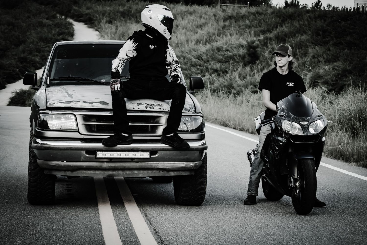 boy sitting on truck and boy sitting on motorcycle
