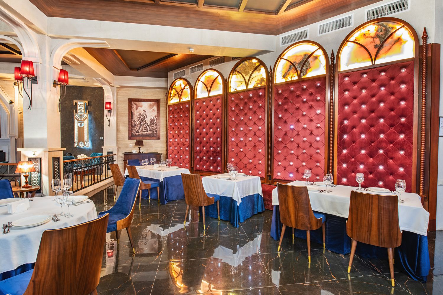 High-end wine bar or tasting room with vibrant red wall panels, arched shelving, and plush seating arrangements.