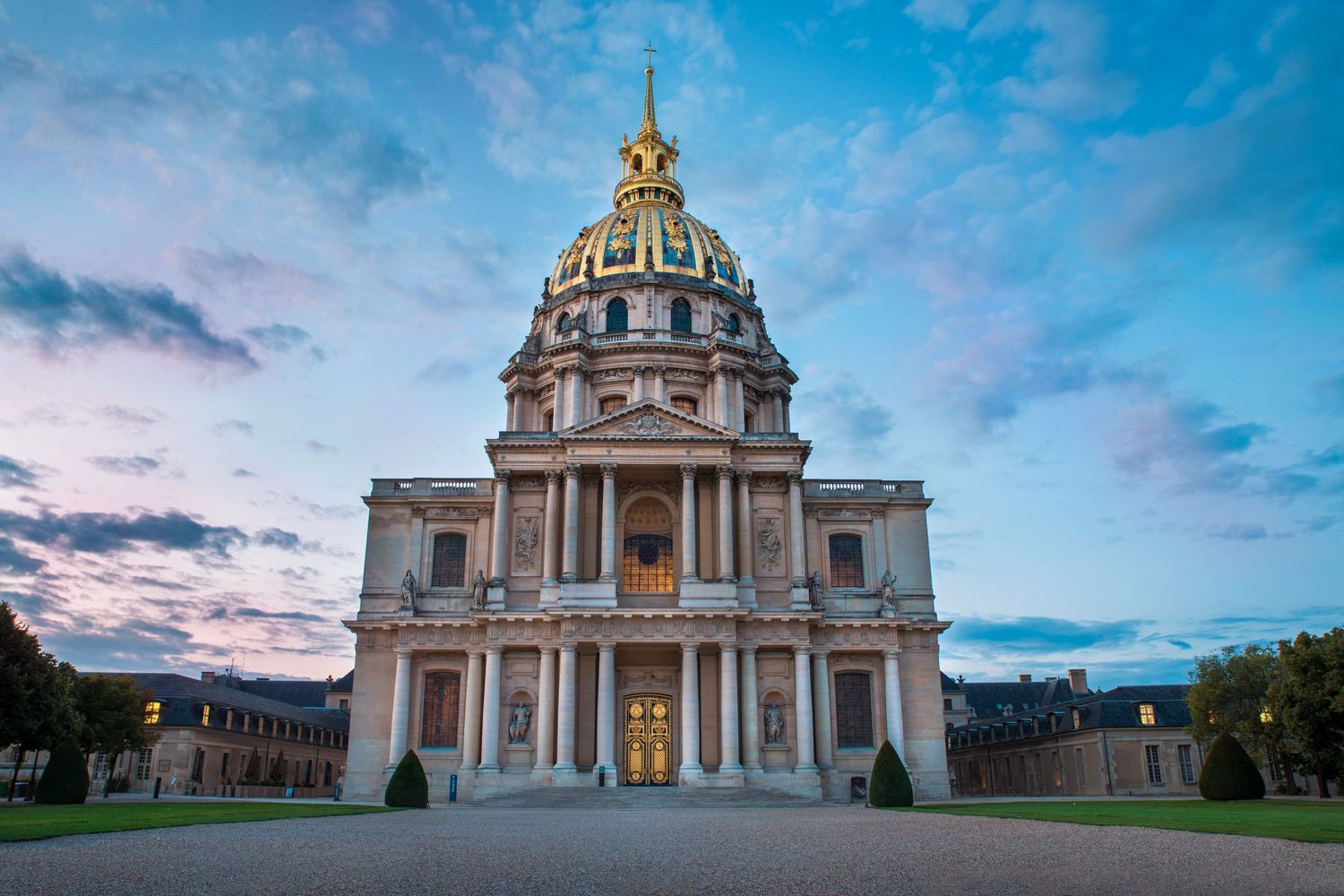 Les Invalides in Paris captured at golden hour — baroque architecture under a dramatic sky.
