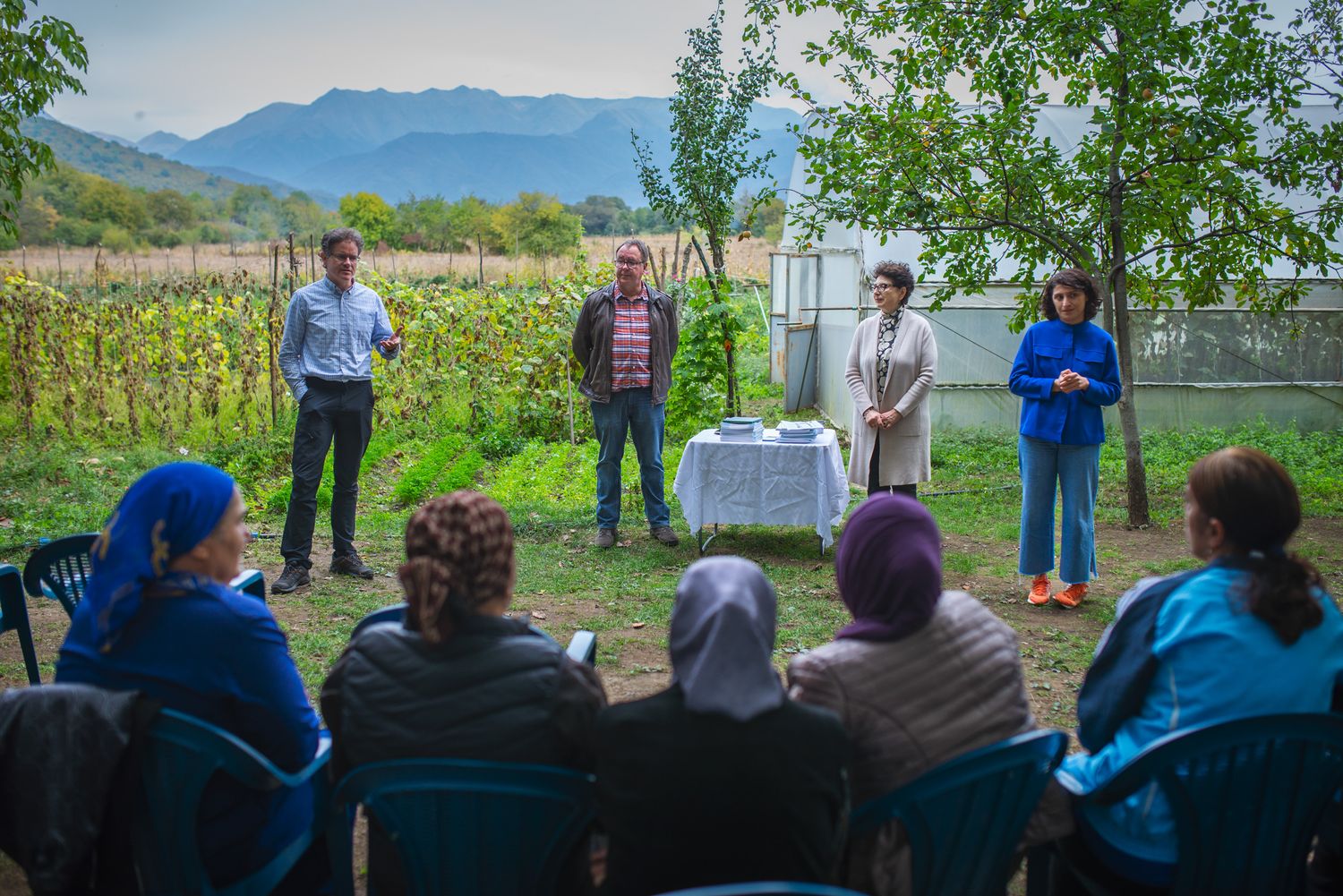 Speakers presenting on sustainable farming in a rural outdoor environment.